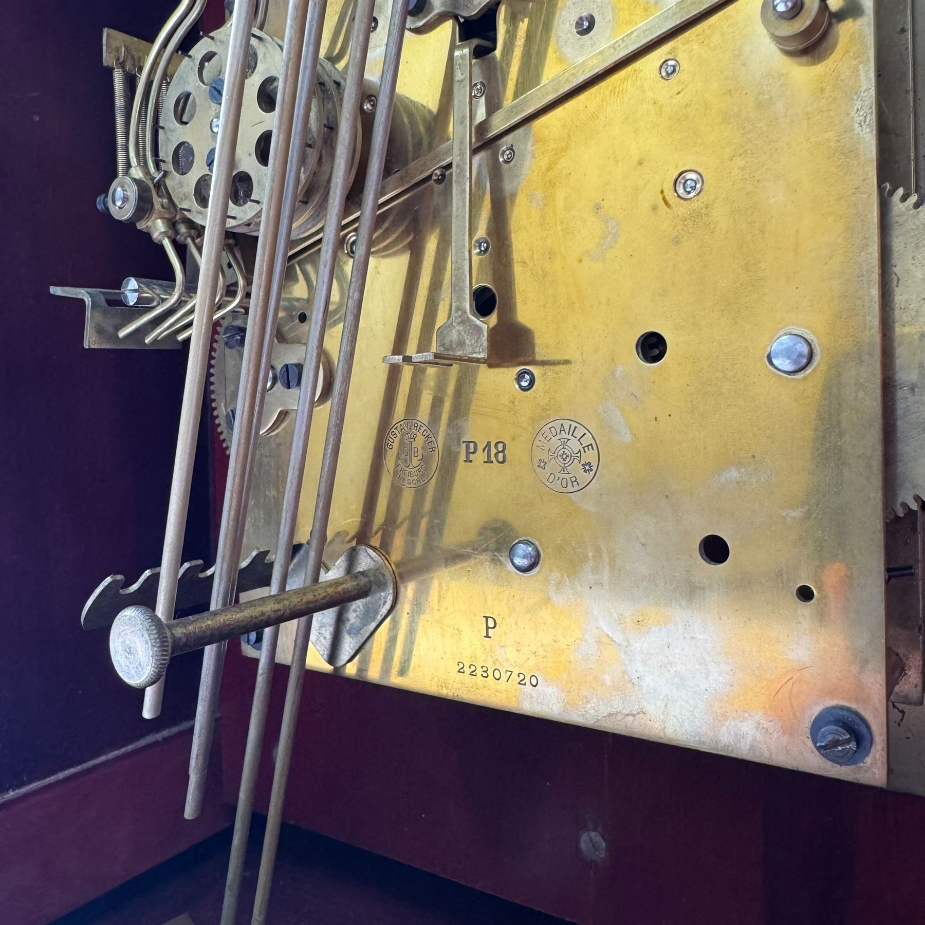Gustav Becker, German 20th century 8-day mahogany cased mantle clock, break arch mahogany case with a round topped door flanked by reeded pilaster with Ionic capitals and raised on a stepped plinth, the dial with engraved Roman numerals, with steel fleur di Lis hands, and  chime /silent dial, H43cm