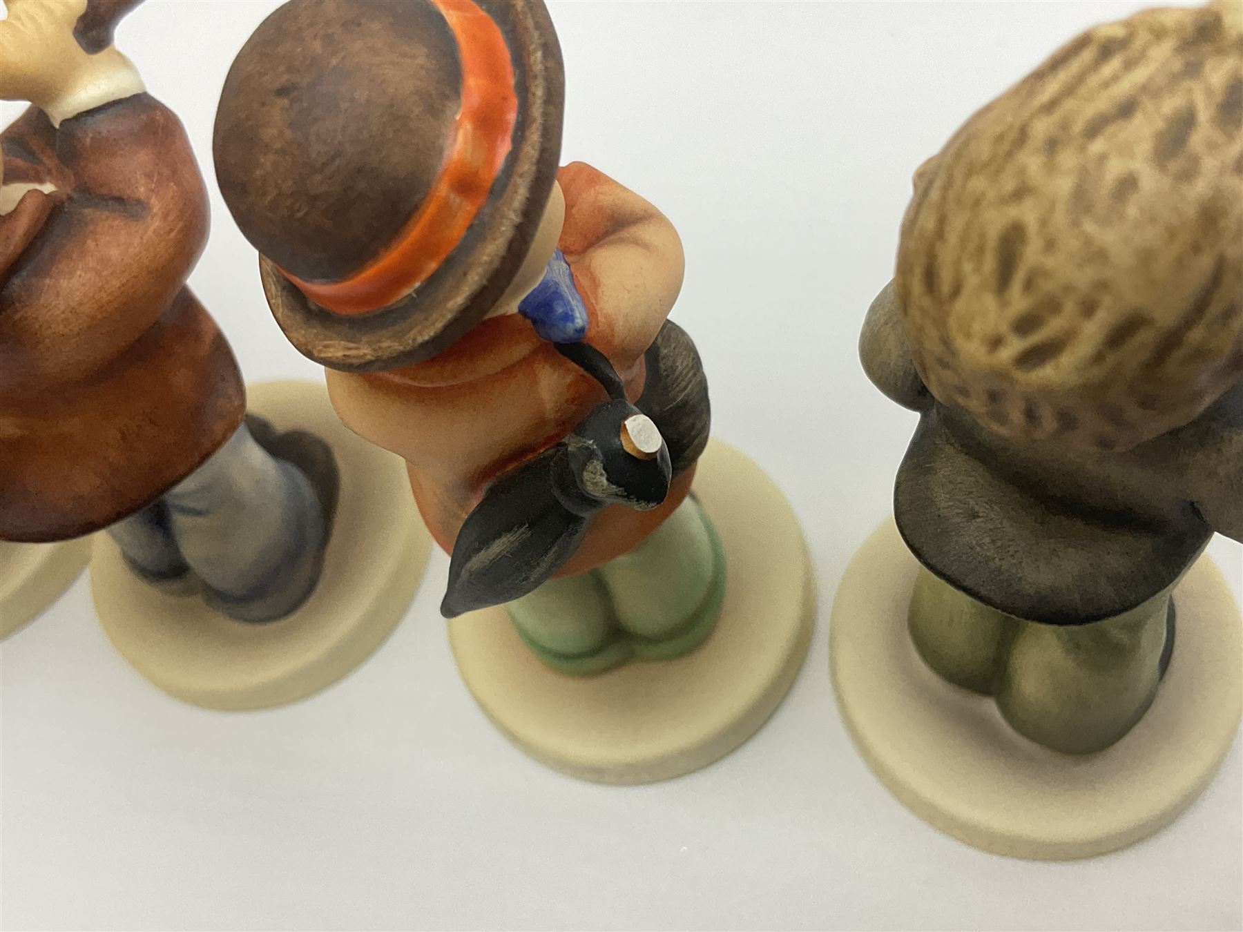 Thirty Hummel figures by Goebel, to include Saluting the Peacekeepers of Operation Joint Endeavor, on wooden plinth, Call to Glory, Celebrate with Song and Soldier Boy