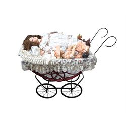 Three porcelain dolls and a wicker dolls pram with lace cover, pram handle H79cm