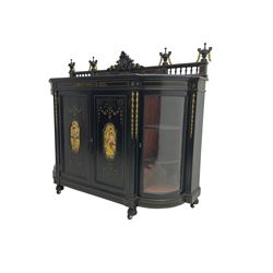 Victorian ebonised credenza side cabinet, raised balustrade back with urn finials and a central carved cartouche, carved and gilded with floral garland decoration, central doors with gilt panels painted with figures sitting over a lake enclosing two shelves, flanked by applied bellflower detail and glazed bow-front side doors, raised on ring turned feet with castors