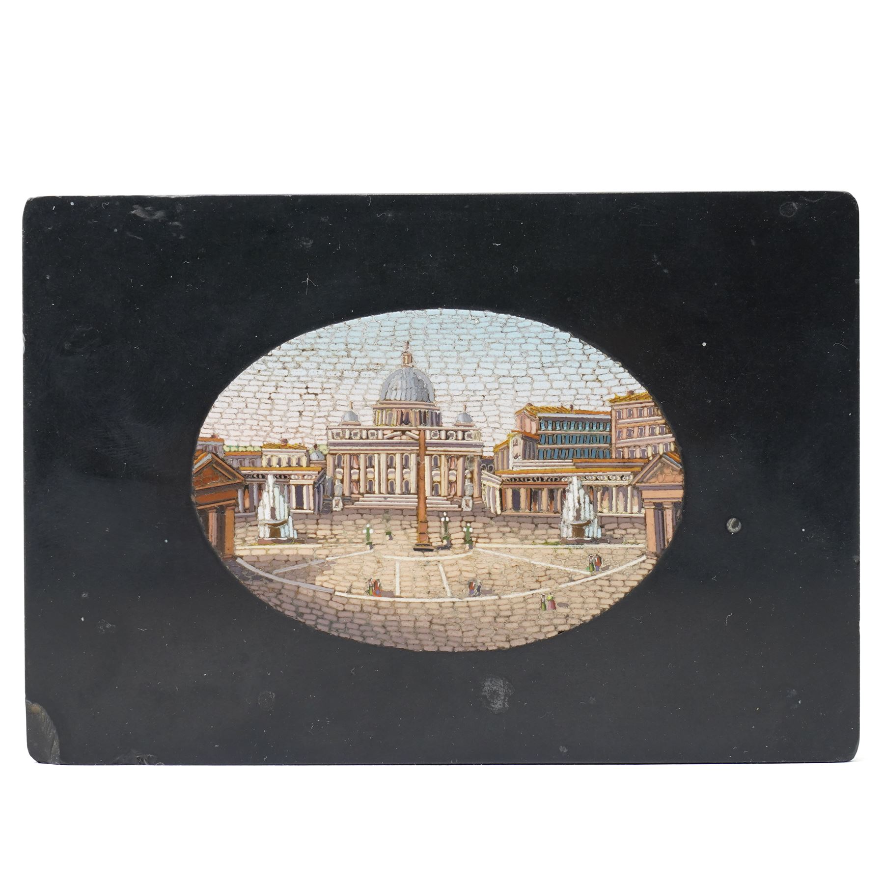 19th-century Italian Grand Tour micromosaic paperweight, the rectangular slab of polished Nero Belgio black marble inset with an oval micromosaic panel finely composed in minute tesserae, depicting a classical architectural view evocative of ancient Rome, centred by a triumphal column and flanked by monumental buildings, 14cm x 9.5cm
