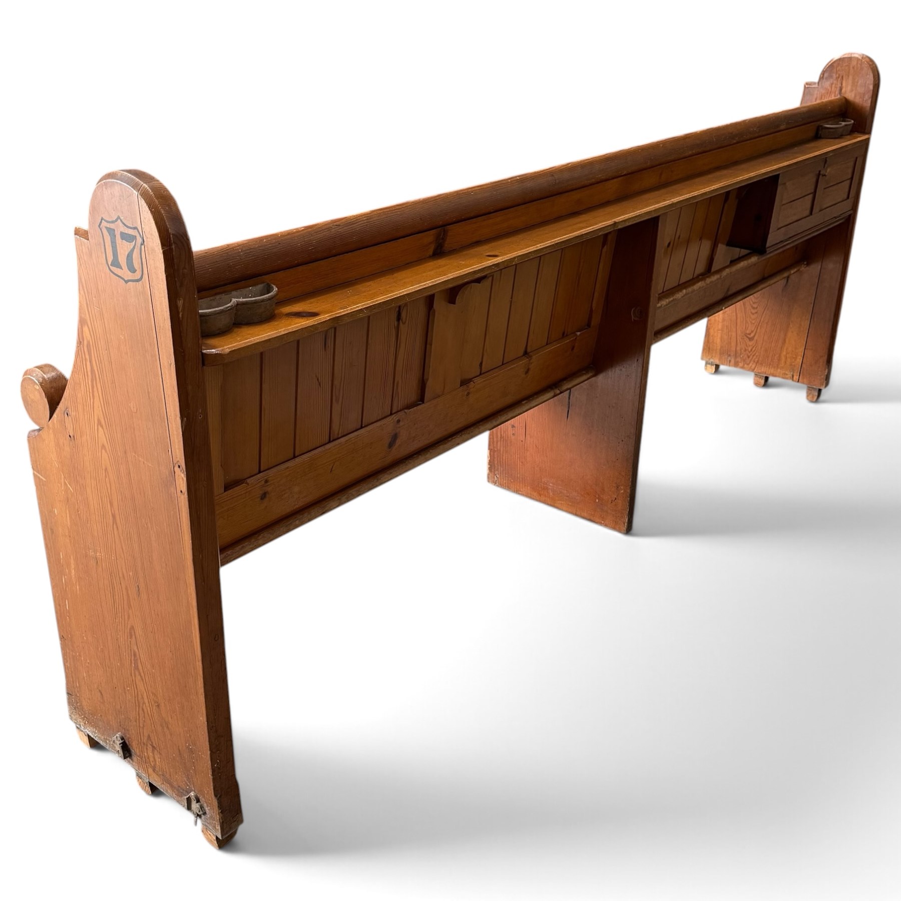 Early 20th century stained pine ecclesiastical church pew, the shaped end supports flanking slatted and panelled back, with black stencilled number '17' to the side