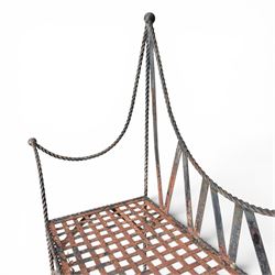 Victorian design wrought iron garden bench, with asymmetrical rope-twist frame, arched back and sides over out-swept arm terminals with ball finials, flanking a lattice seat, in antique black-painted weathered finish