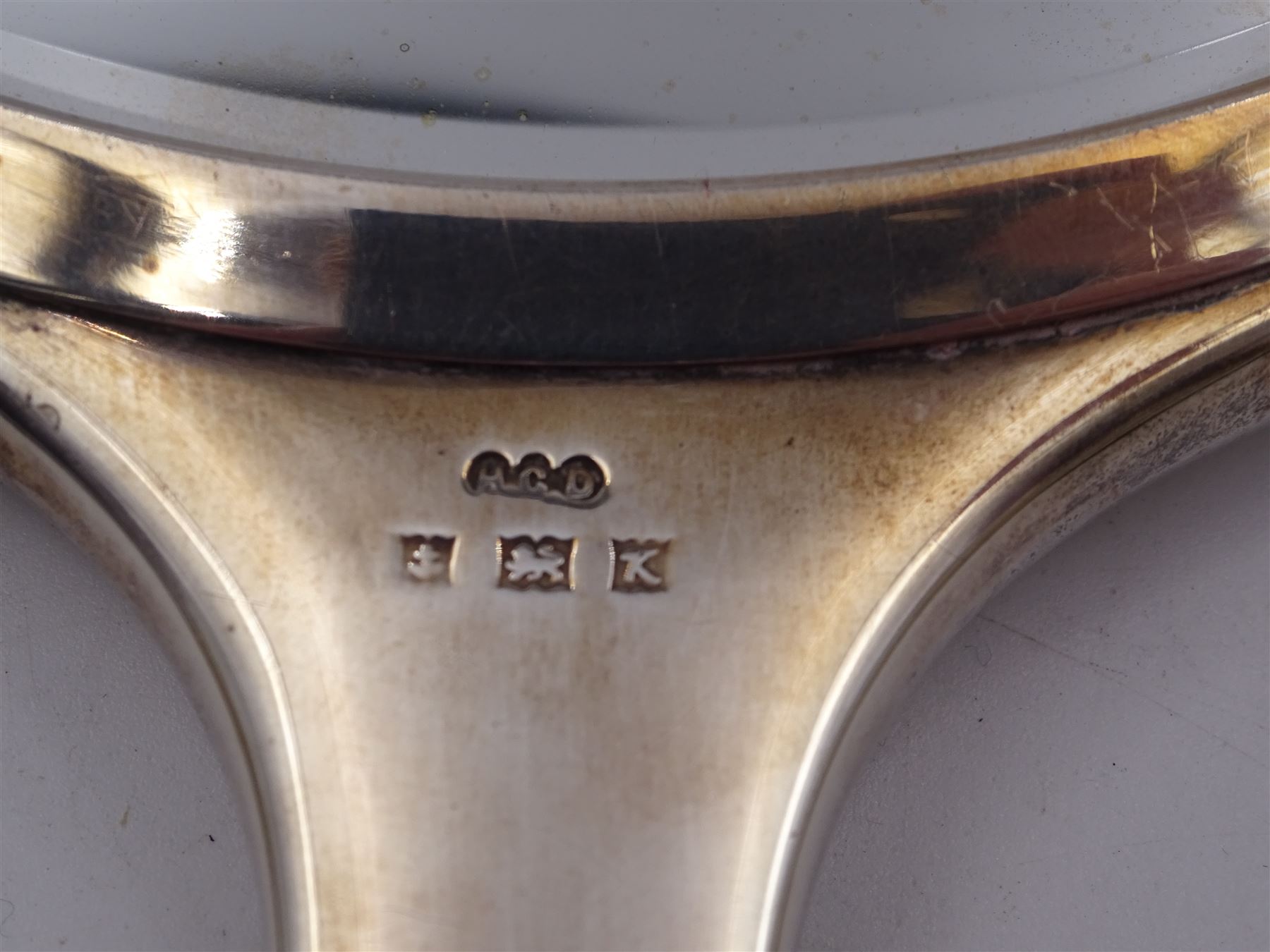 Mid 20th century silver mounted three piece dressing table set, comprising hand mirror, hair brush and clothes brush, each with white guilloche enamel decoration and set with a carved green hardstone, hallmarked Henry Clifford Davis, Birmingham 1959