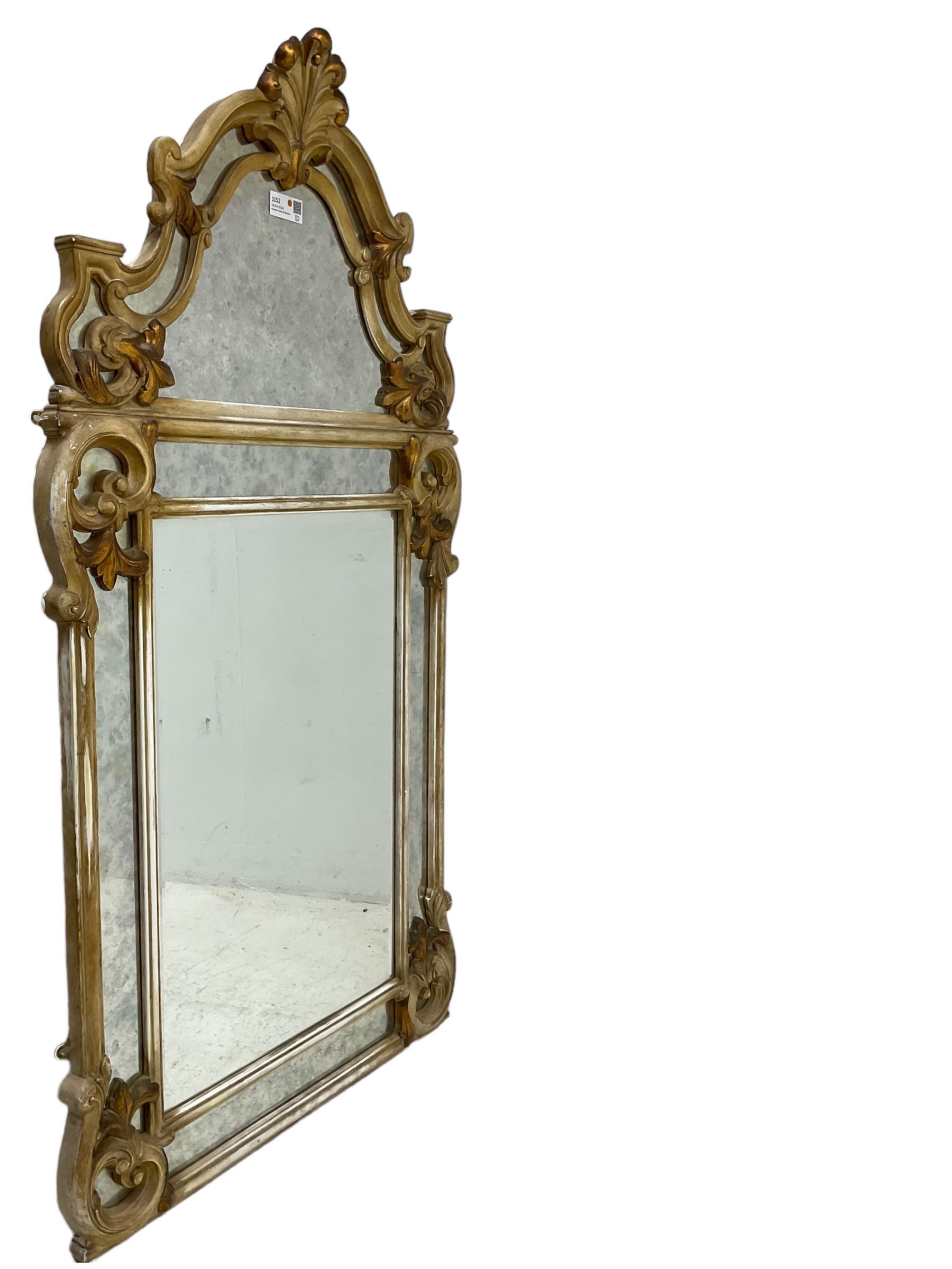 Victorian design parcel gilt wall mirror, shaped cresting with foliate cartouche pediment, decorated with C-scrolls and scrolled foliage, moulded frame with segmented mirror plates