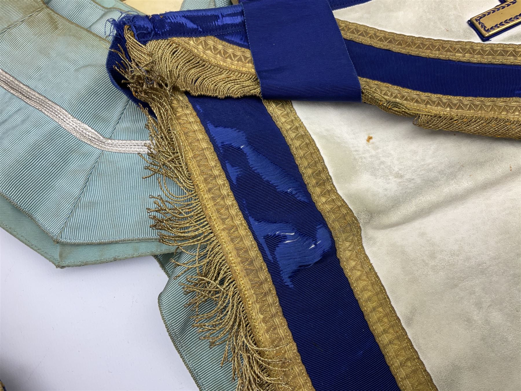 Two Masonic kid leather aprons, one with sash and cuffs, the other with sash, each marked 'Yorkshire North and East Ridings'; and three other unmarked Masonic aprons with sashes