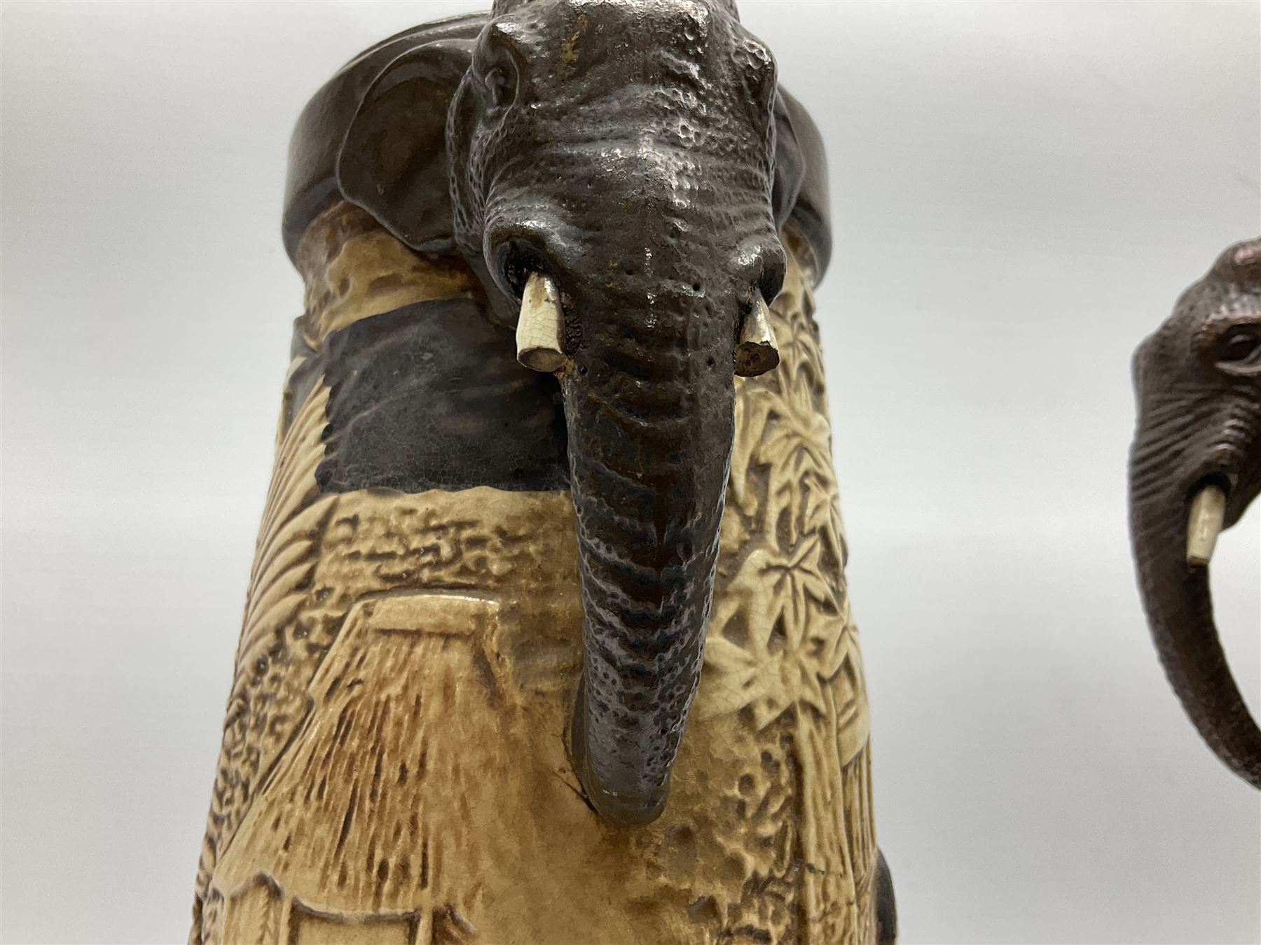 Pair of Bretby vases of tapering cylindrical form decorated with elephants, cranes and fishermen, the bodies with twin elephant mask handles, with coppered borders, raised upon three bun feet, stamped Bretby 2246 marks beneath, H32cm