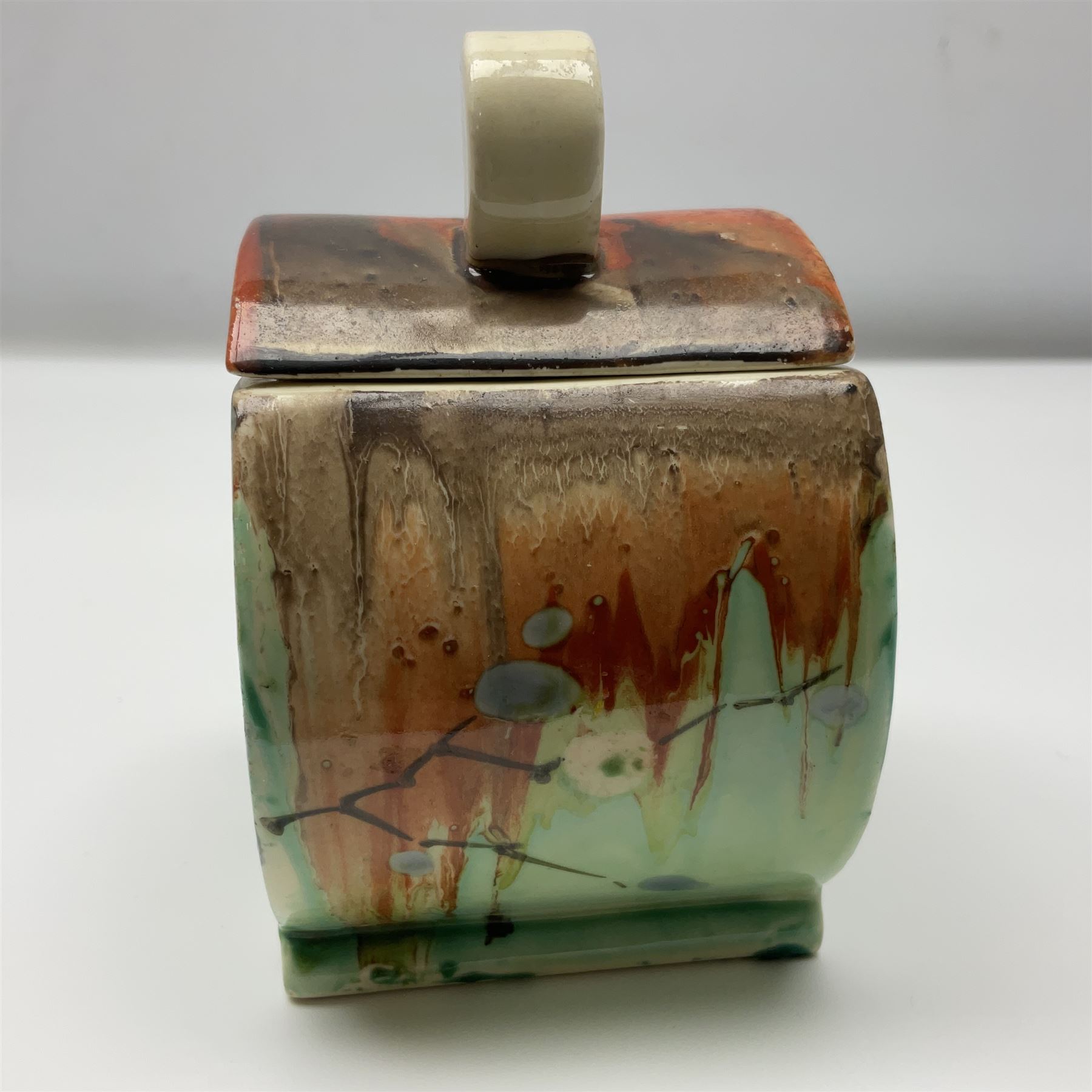 Clarice Cliff Bizarre for Wilkinson Pottery, Bon Jour shape preserve pot decorated in the May Blossom pattern, hand painted with stylised blossom upon a streaked merging green and orange ground, with conforming lift off lid, with black printed mark beneath, H10cm