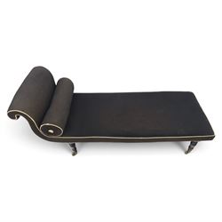 Victorian ebonised chaise longue, upholstered in black fabric with scroll headrest and bolster cushion, rectangular seat with rounded corners, raised on turned supports terminating in brass and ceramic castors