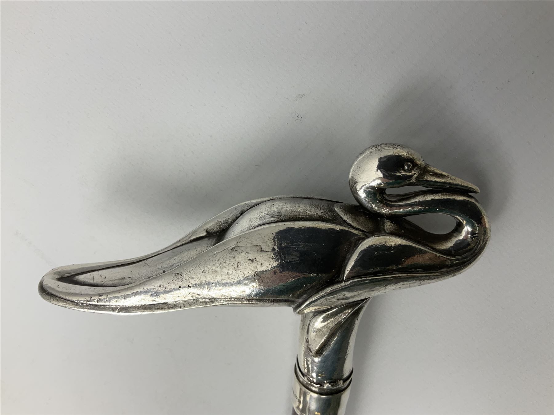 Art Deco style Italian 'Rivestito' covered silver walking stick handle, modelled in the form of a swan, stamped 'R', upon a silver collar hallmarked Birmingham 1986, makers mark DH-L, and hardwood shaft, L96cm

Provenance by vendor repute: 
This walking cane comes from a private collection amassed by the current vendors mother who was an Antique dealer specialising in walking sticks, working at the Portobello Road Antique Market in London for over forty years. 
In 1988 the prop crew from LWT (now ITV) visited Portobello Road looking for, amongst other items, a signature stick for David Suchet to use in his portrayal of Agatha Christie's Poirot. 
At the time this particular walking stick was one of five in possession. The prop crew chose and purchased another of the five which was then used by Suchet throughout all seventy episodes of the much loved series. 
Following the conclusion of the series Suchet was gifted his particular cane, which has been loaned to and can now be seen at the Agatha Christie Gallery at the Torquay Museum. 
