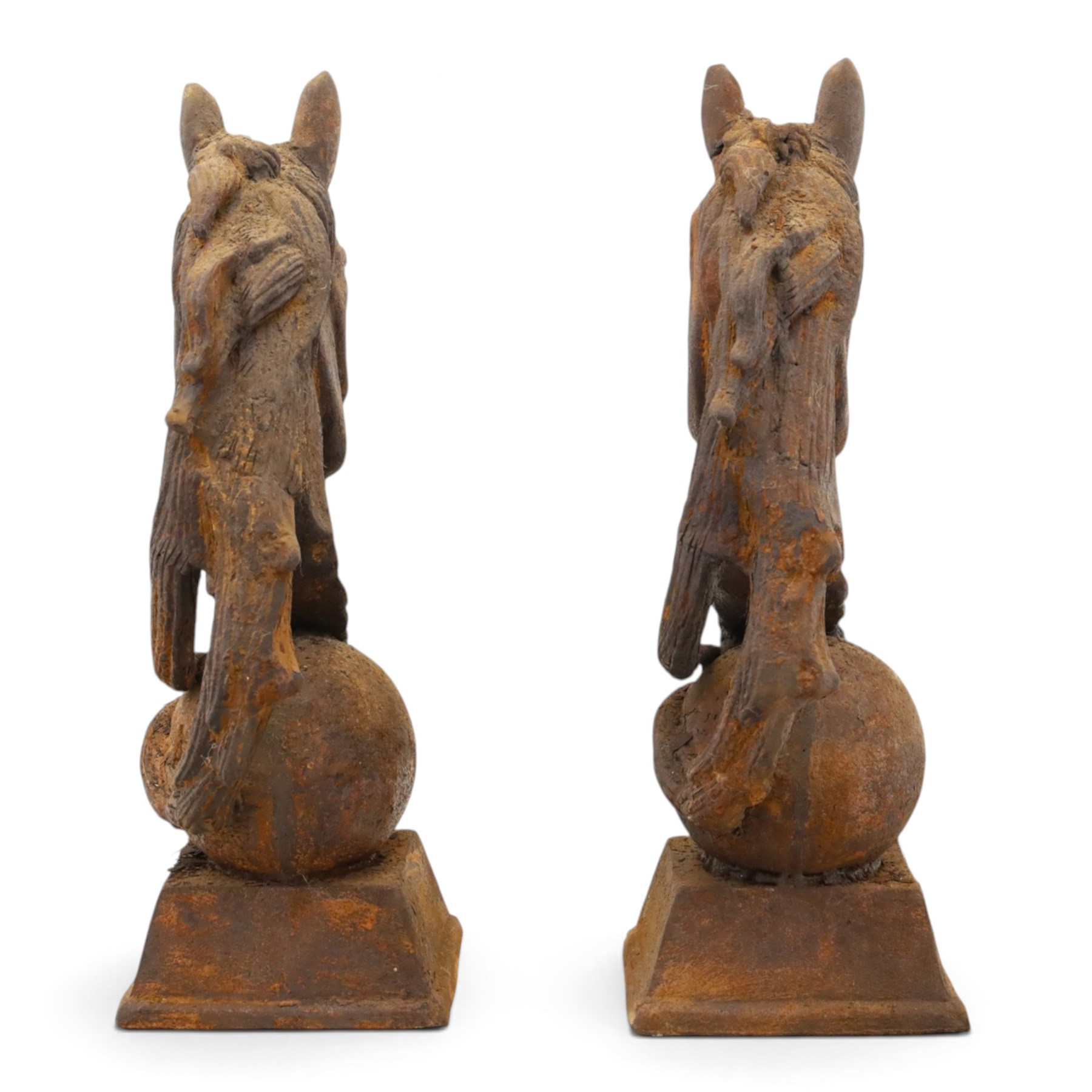 Pair of antique cast iron garden finials or statues of horse heads or busts, the heads with flowing and pierced mane, mounted on spherical finials over square tapering bases