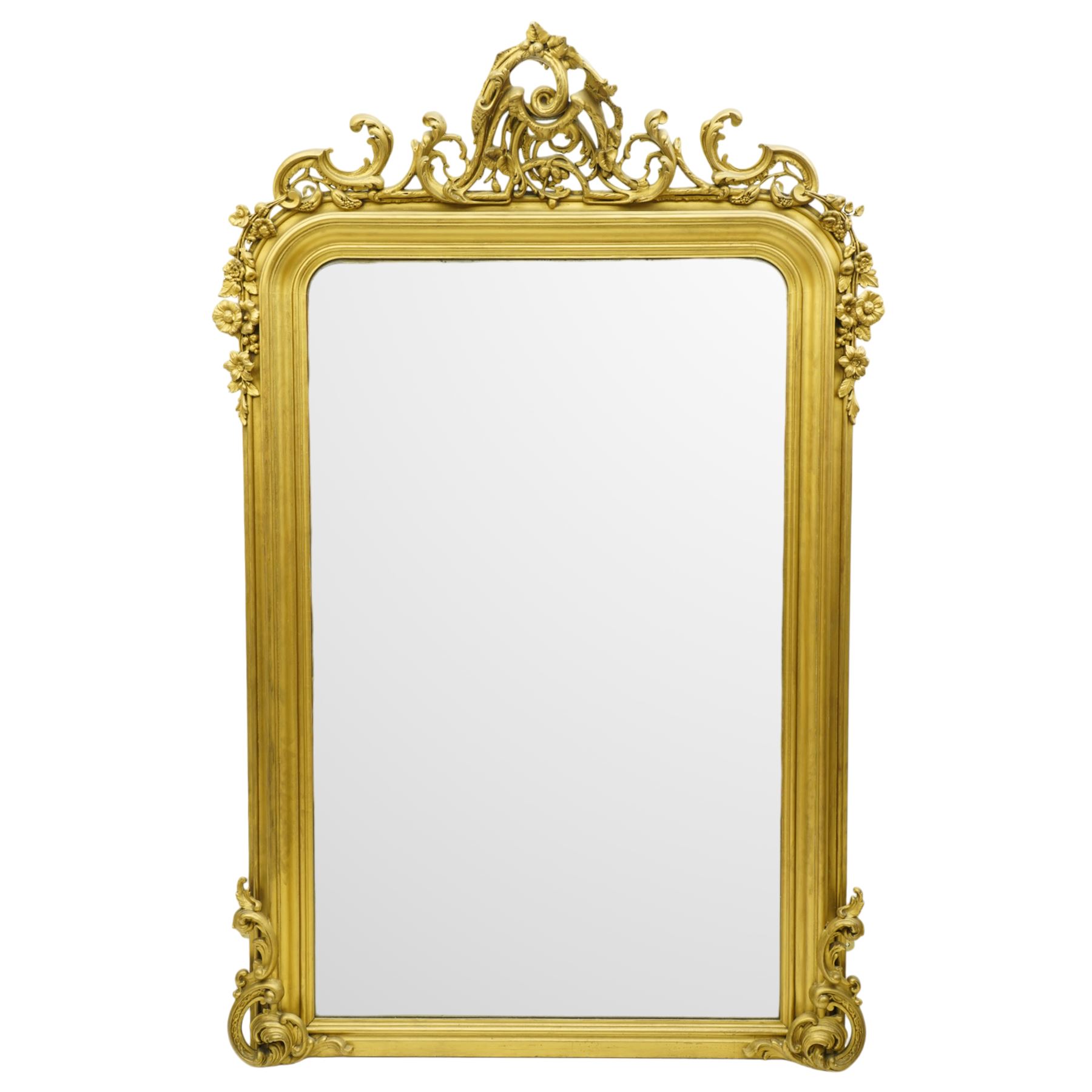 19th century Rococo Revival large gilt framed mirror, with bevelled rounded rectangular plate enclosed by a carved giltwood frame, surmounted by pierced scroll and foliate cresting, floral and scroll details to sides and corners