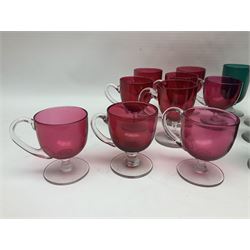 Collection of 19th century coloured glasses, to include nine cranberry glass punch cups, each with clear glass handle and foot and a set of six green glasses, with short clear stems, tallest H10cm