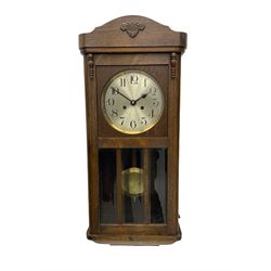 A 1930’s wall clock in an oak case with a full-length door, three glazed panels and visible pendulum, case with a shaped pediment and applied carving, 6” silvered dial with Arabic numerals, minute track and steel baton hands, eight day going barrel movement striking the hours on a gong.

	



