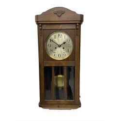 A 1930's wall clock in an oak case with 