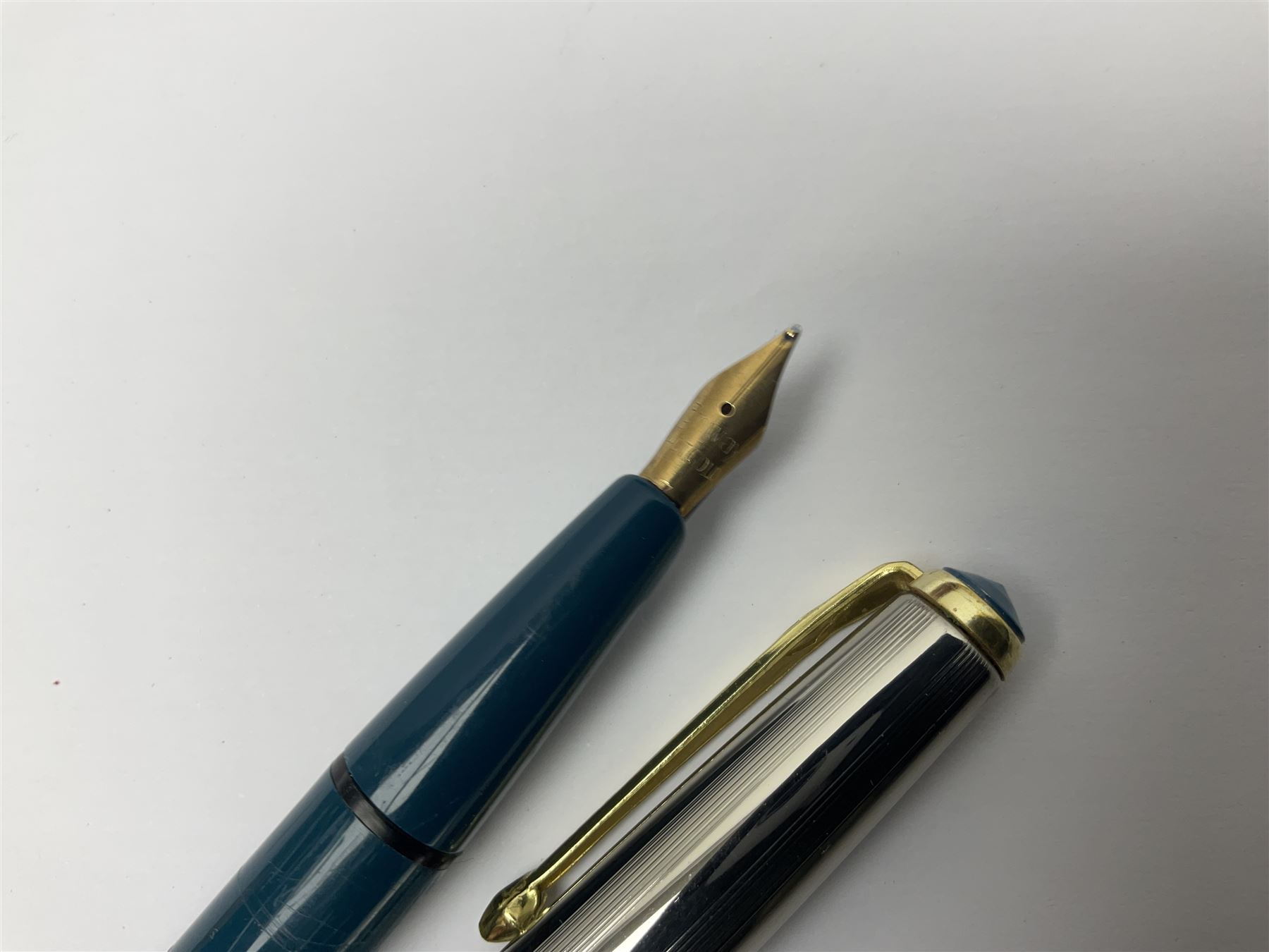 Three fountain pens, to include Conway Stewart 'Dinkie 550' and 'Conway 57' and a Parker 'Slimfold', all with 14ct gold nibs, together two roller ball pens, including a Parker example and a Swarovski Crystal paperweight