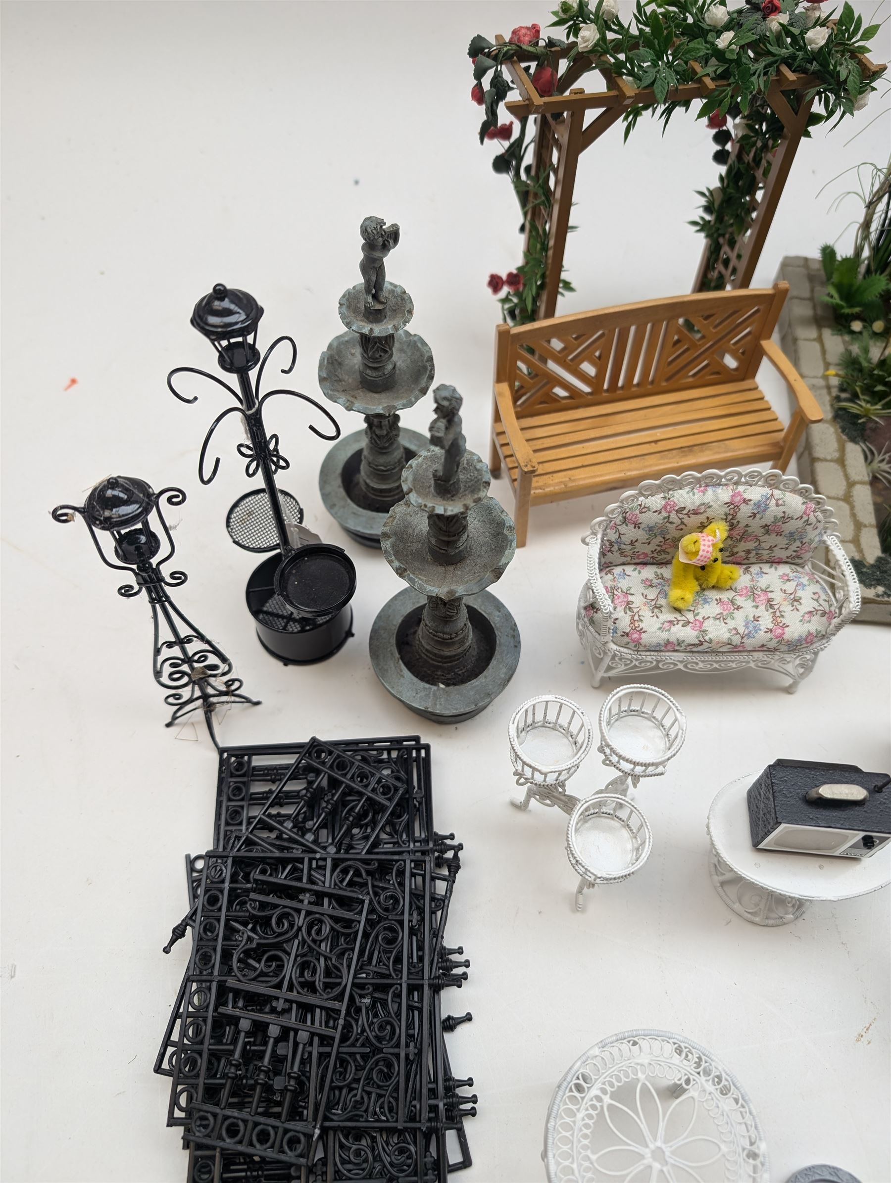 1:12 scale dolls house conservatory and garden accessories, including white wooden glazed conservatory on a stone effect base, black and white metal garden seating, barbecue, plant shelves, parasol, barbeque accessories, large planters, rabbit hutch, animals, chimenea, etc