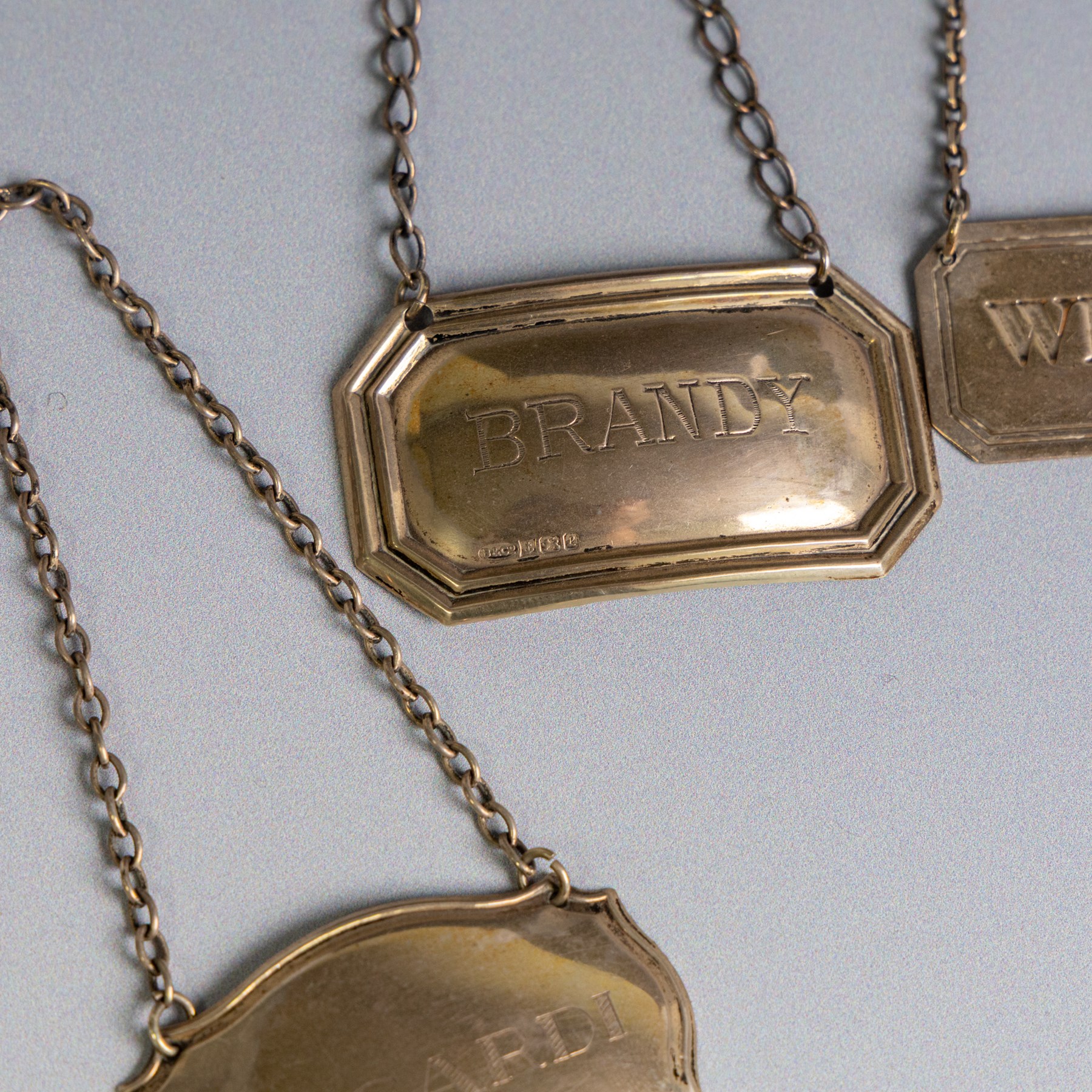 Five silver decanter labels, of varying design, including Bacardi, Vodka, Rum, Brandy and Whisky, all hallmarked together with two silver plated Gin and Sherry examples