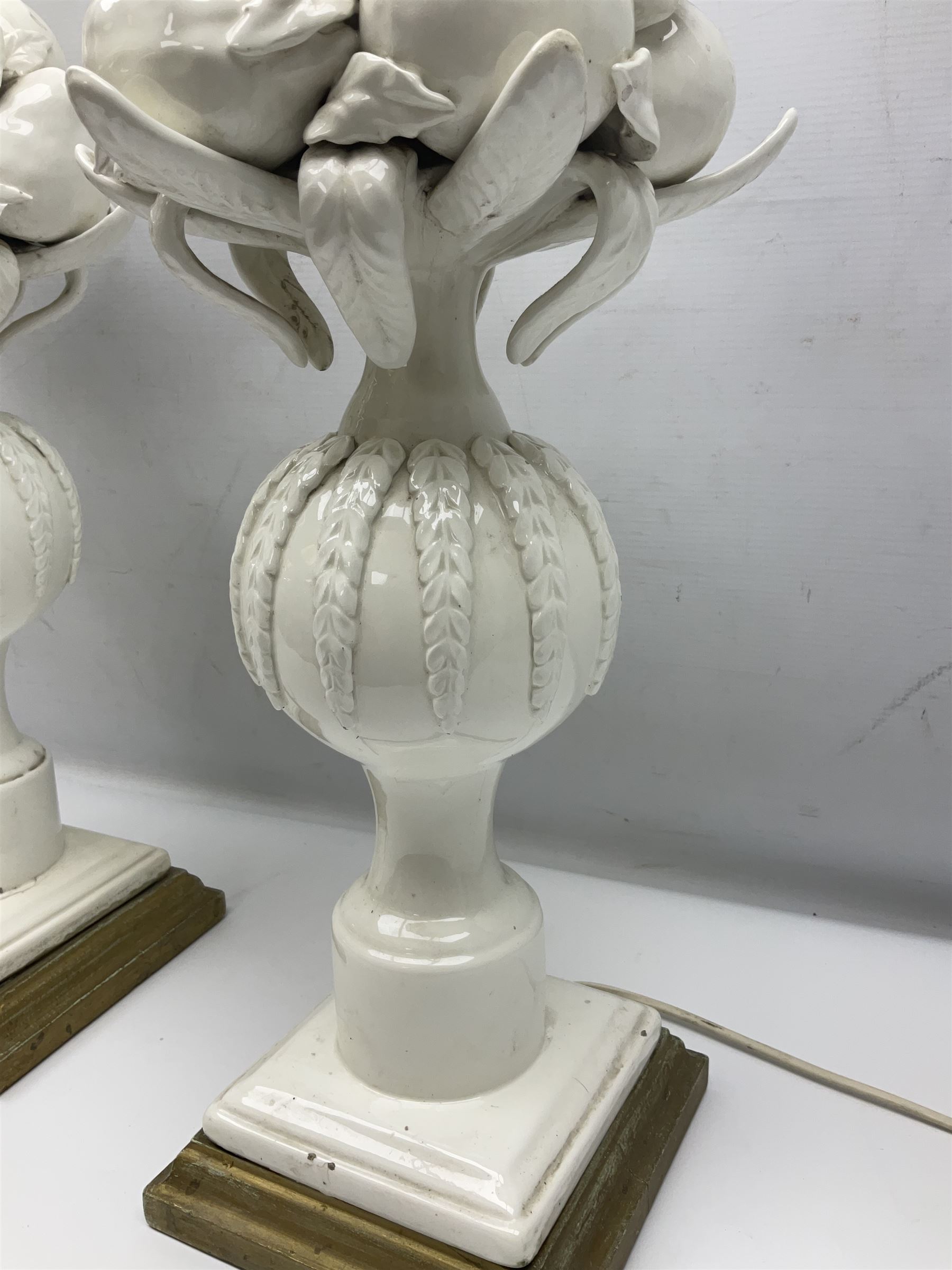 Pair of Casa Pupo white-glazed table lamps, modelled as a fruit upon a column of baluster form with foliate decoration, on a giltwood base, H62cm