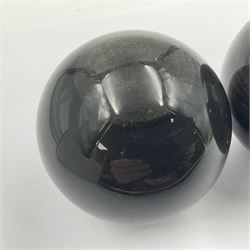 Pair of obsidian spheres, upon carved stone stands, D8cm 