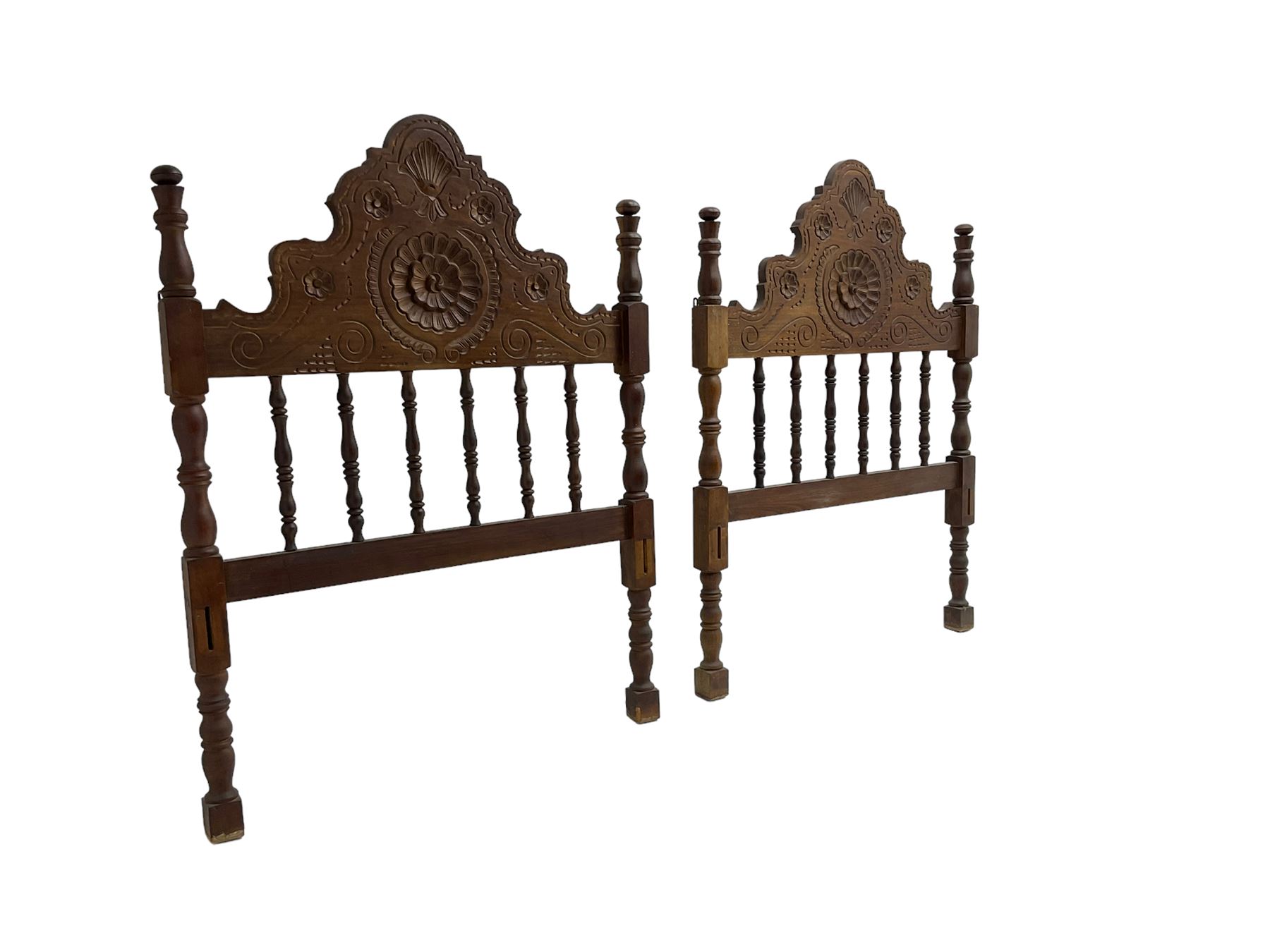 Pair Spanish stained beech single 3' bedsteads, spindle turned backs and carved with scrolling floral decoration 