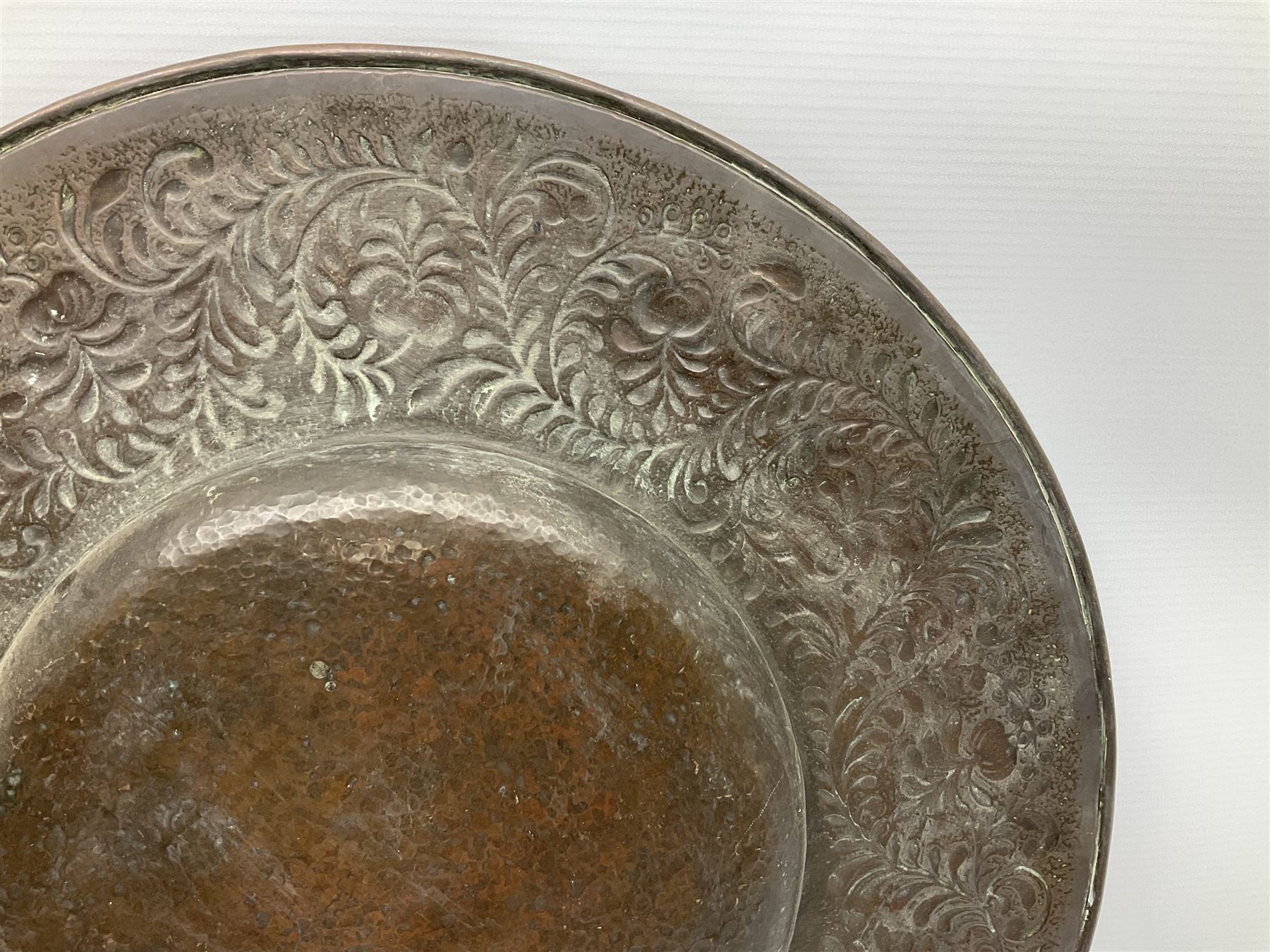 Arts and Crafts Keswick School of Industrial Arts copper charger, decorated with planished centre and repousse scrolling foliate tendrils to rim, D44cm