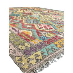 Anatolian Kilim cream ground rug, decorated with repeating diamond motifs in red, blue, yellow, and green, bordered by narrow bands of stylised geometric patterns in contrasting shades