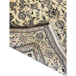 Central Persian Nain rug, wool with silk inlay, ivory ground decorated with scrolling and interlaced branch with stylised plant motifs, central floral medallion, triple band border with repeating design