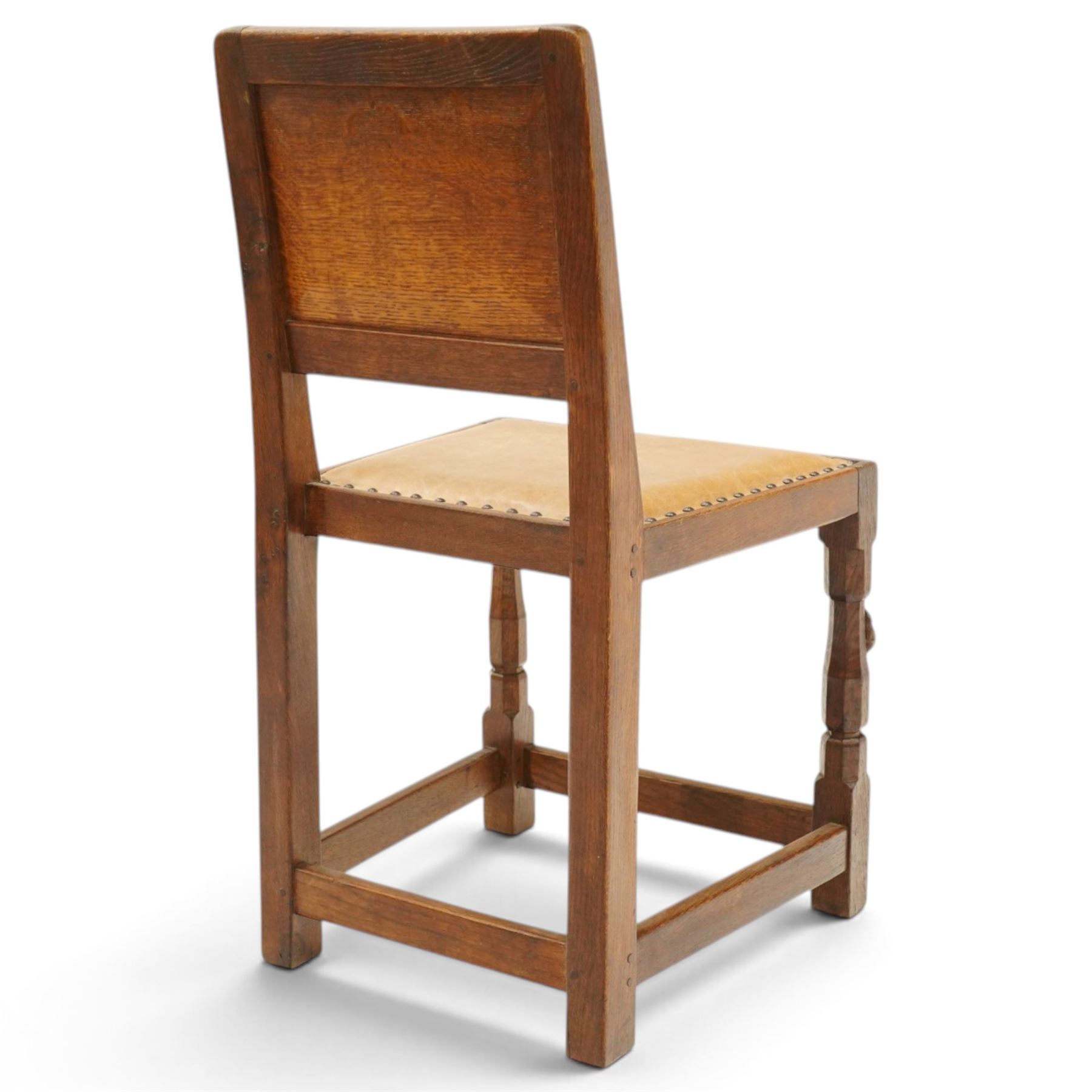 Mouseman side chair- panelled adzed back over tan leather upholstered seat with studwork, on octagonal front supports united by stretchers, each with signature carved mouse, by the workshop of Robert Thompson, Kilburn