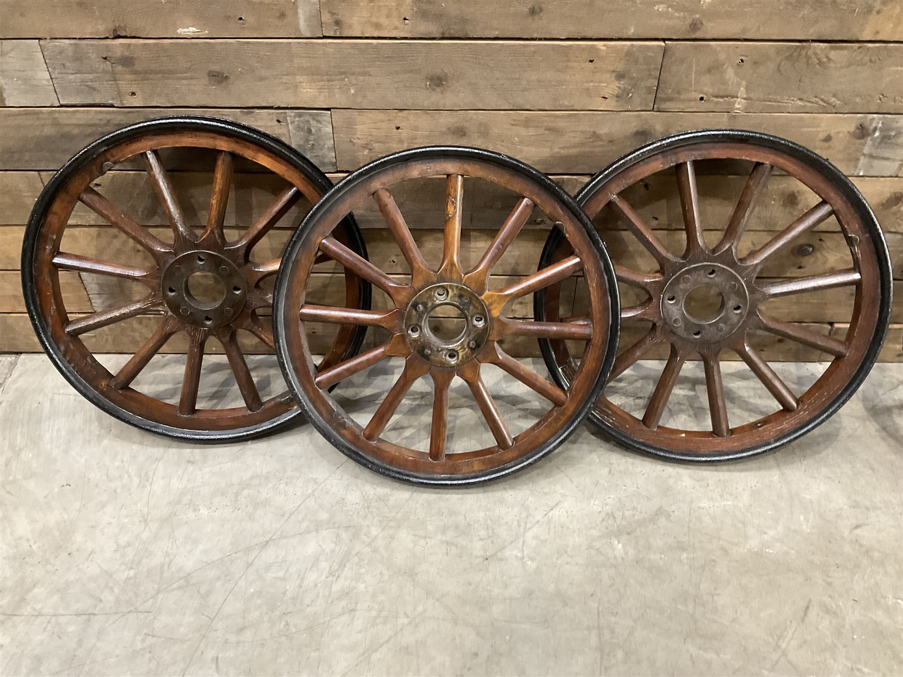 Set of four wheels from an early 20th century cart, wood with metal outer