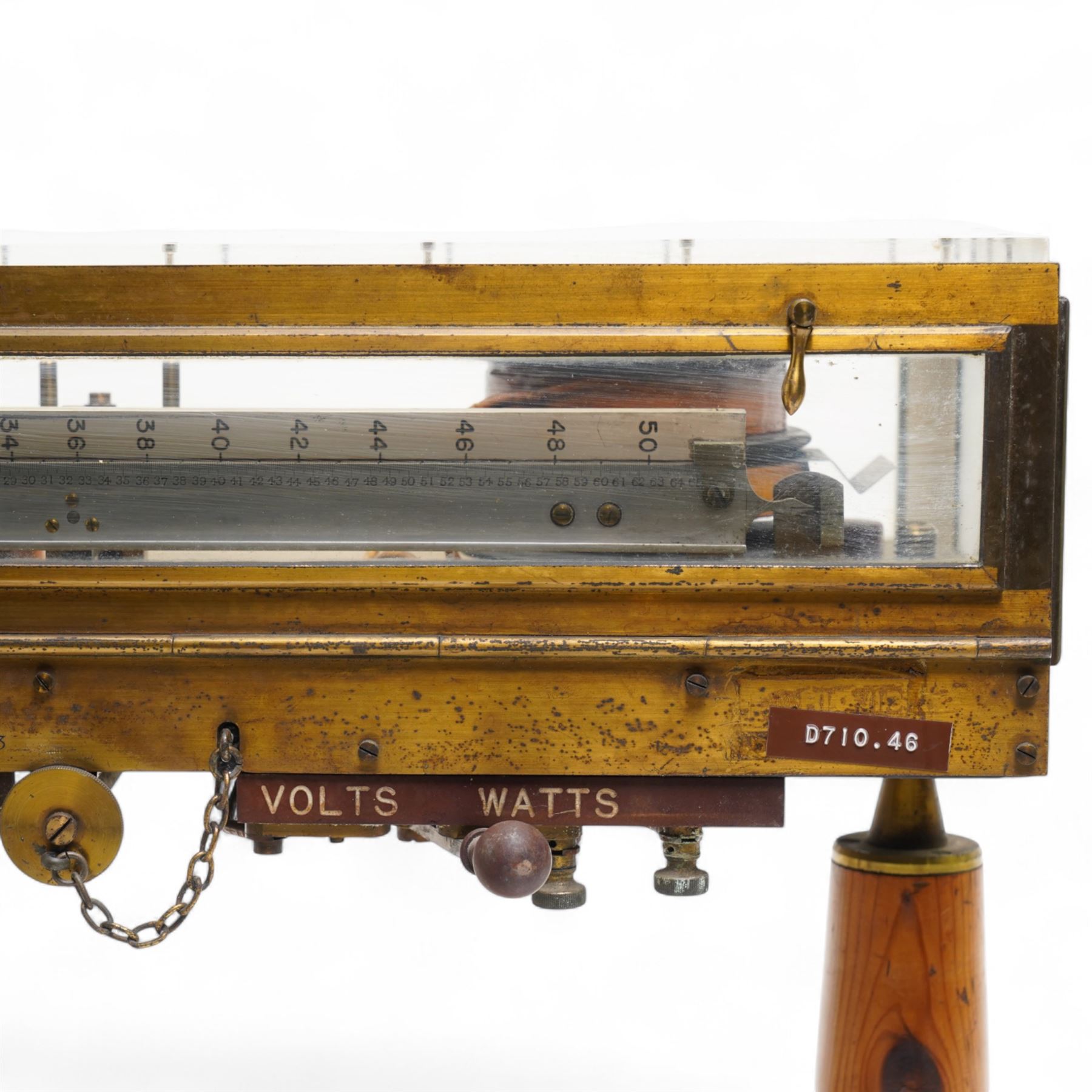 Lord Kelvins Patent electric current balance, no. 823, by Kelvin & James White Ltd Glasgow & London, with two pairs of horizontally mounted coils, suspended beam balance mounted on an ebonite base under glass and brass cover, with box of weights and accessories, raised on three wooden supports, W51cm H37.5cm