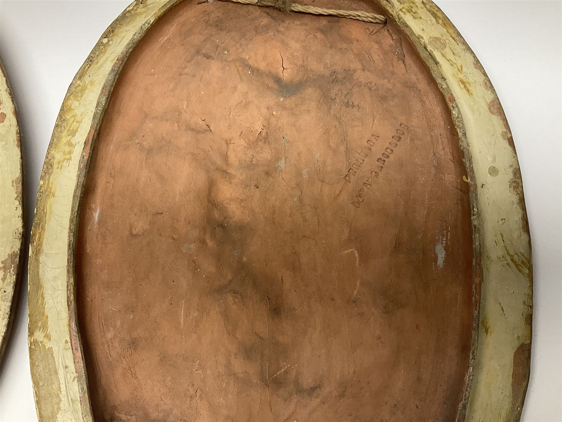 Pair of 19th century classical terracotta relief wall plaques depicting the goddess Hygeia and another goddess, seated holding an ewer, each of oval form, indistinctly signed, each stamped Ferreira verso, H42cm, W30cm