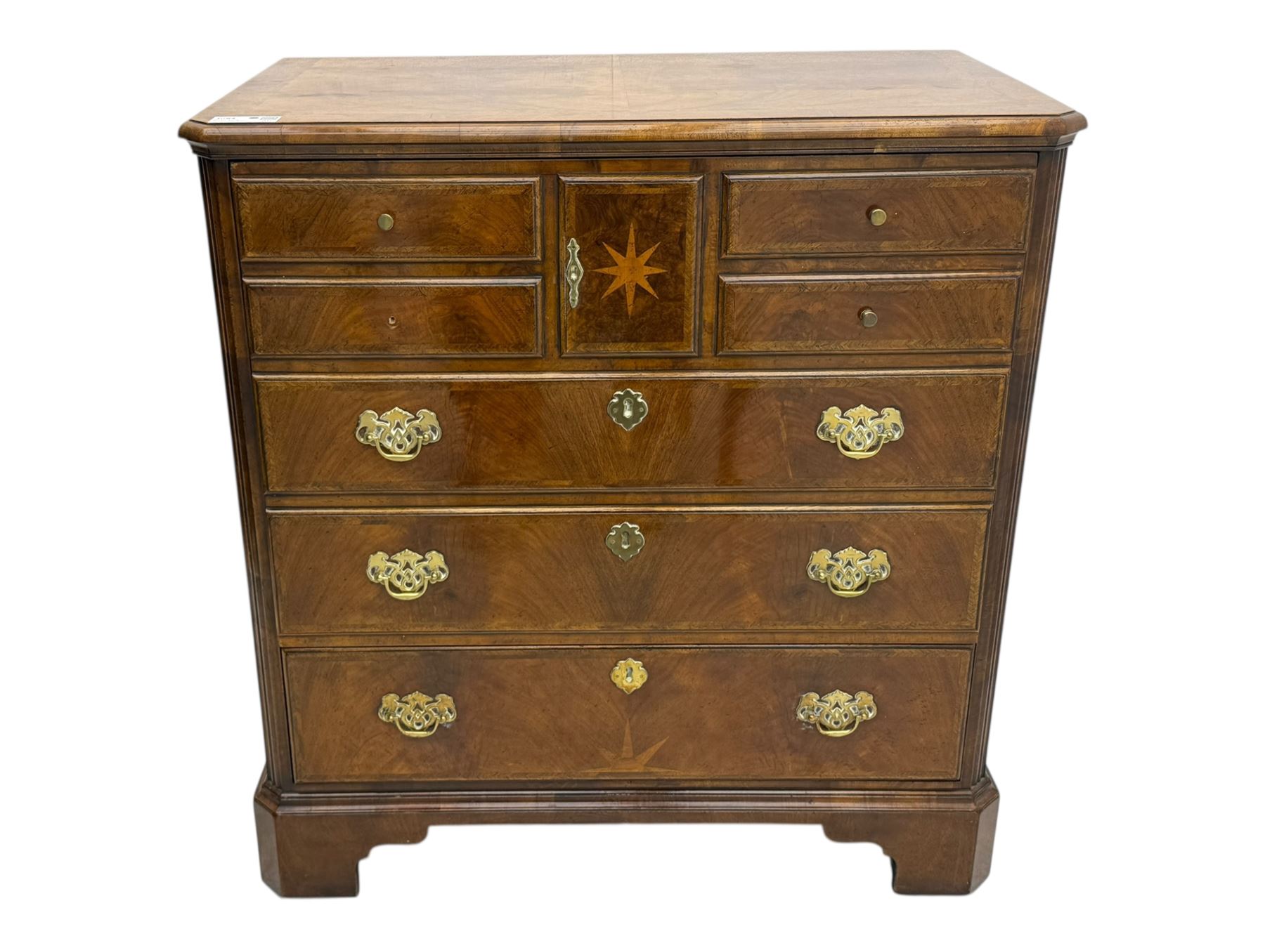 Late 20th century walnut veneered television chest in Georgian style, rectangular top over simulated drawer front with central marquetry star inlay, opening to a shelved TV compartment, lower section fitted with one long drawer, brass handles and ogee bracket feet