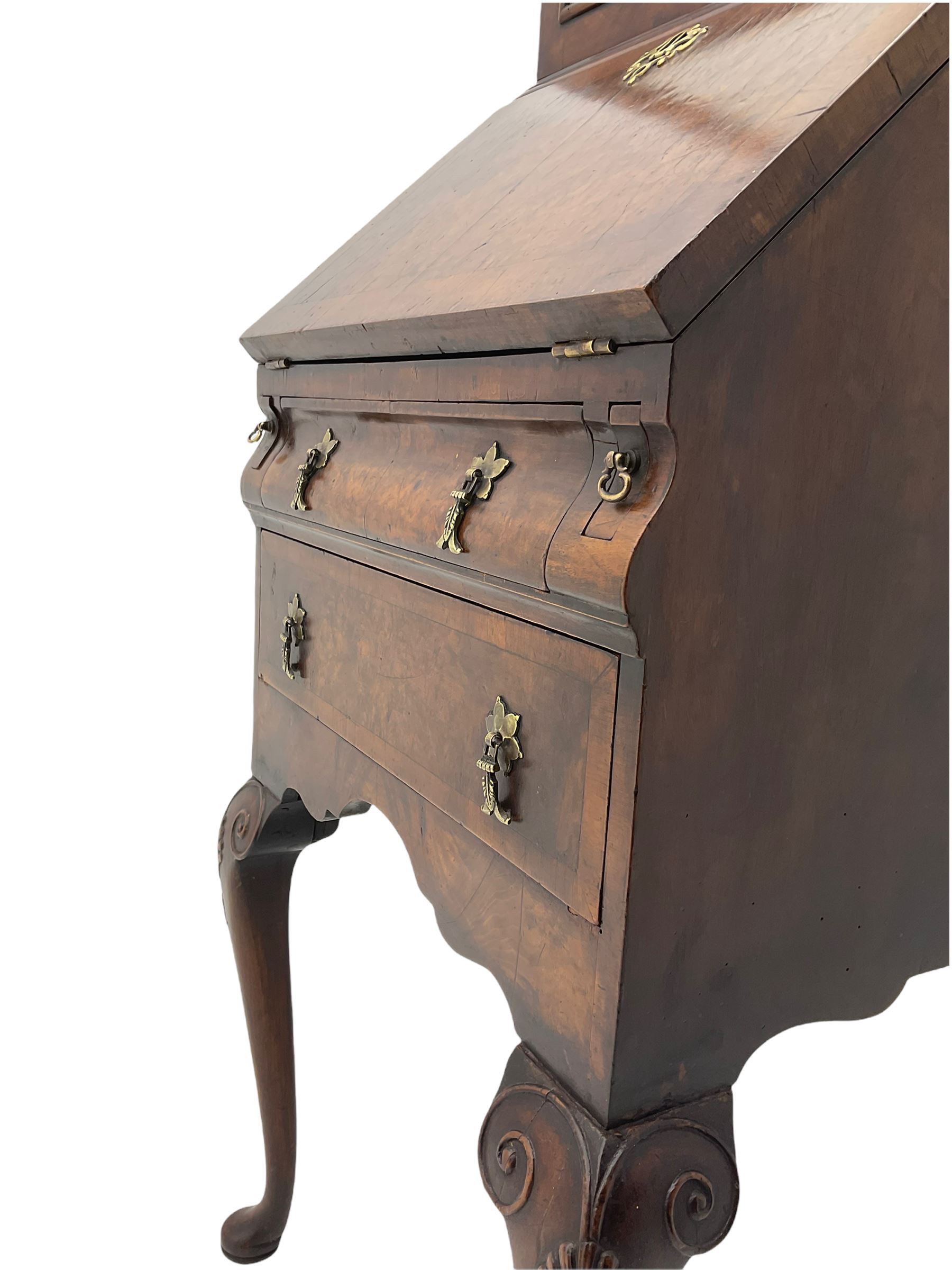Small early 20th century Queen Anne style bookcase on bureau secretaire, the moulded arched pediment over mirrored door in shaped frame, the bureau fitted with fall front enclosing curved fitted interior, cushion moulded drawer over single drawer, on scroll and shell carved cabriole supports