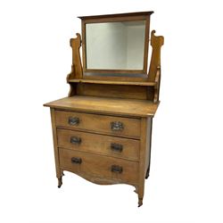Arts & Crafts period oak dressing chest, raised swing mirror over three graduating drawers, shaped apron, on turned supports with castors