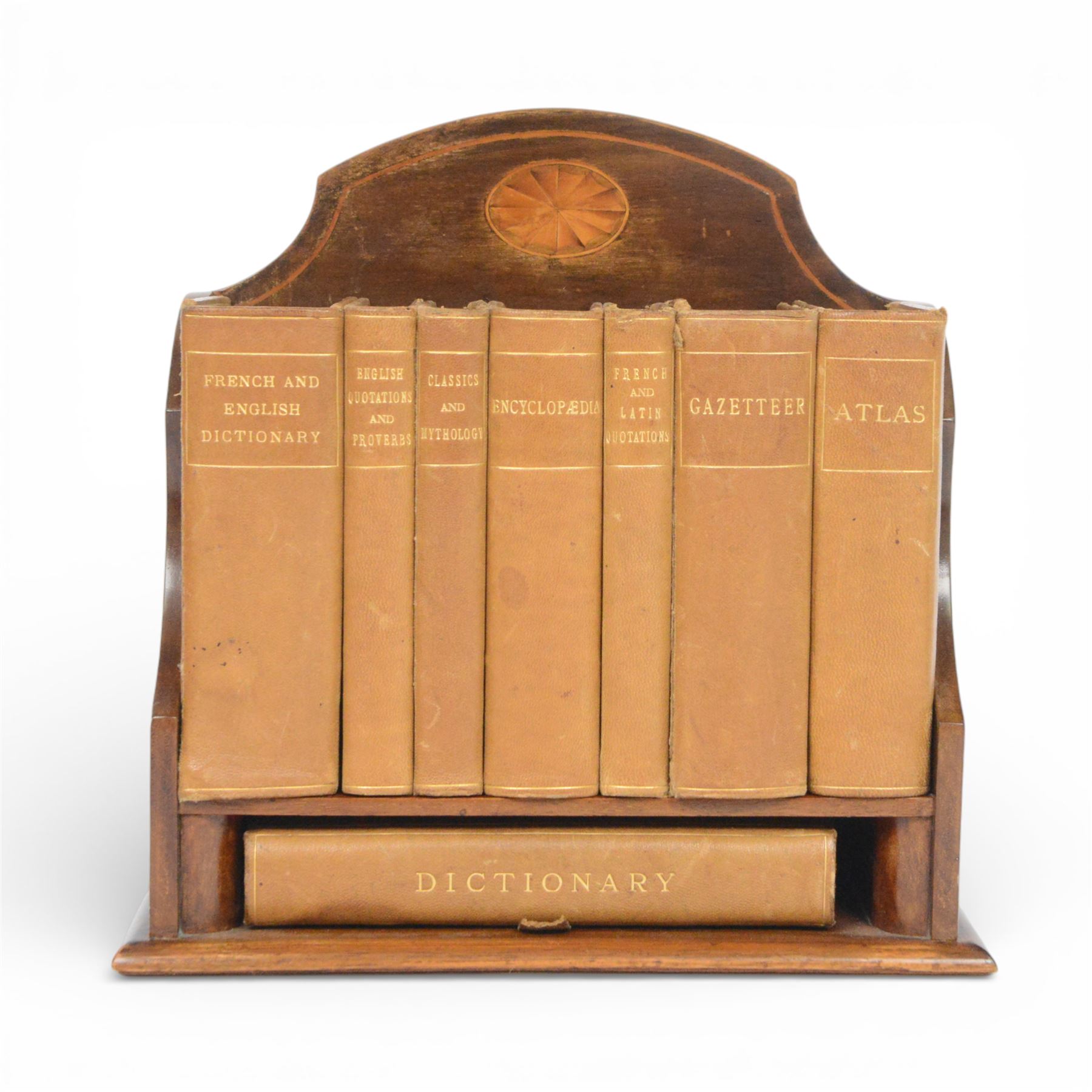 Edwardian Asprey mahogany desktop book trough, the segmental arched back with inlaid fan patera and serpentine shaped sides, above single recess and moulded base rail, housing Asprey & Co Ltd leather bound reference library, comprising Dictionary, French and English Dictionary, English Quotations and Proverbs, Classics and Mythology, Encyclopedia, French and Latin Quotations, Gazetteer, and Atlas, book trough, 22cm x 22.5cm x 11cm
