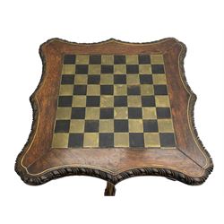 Late 19th century carved hardwood chess table, shaped square top inlaid with brass, foliate carved edge and pierced skirt, the column carved with coiled dragon, flower heads and scrolls, three supports carved with foliage