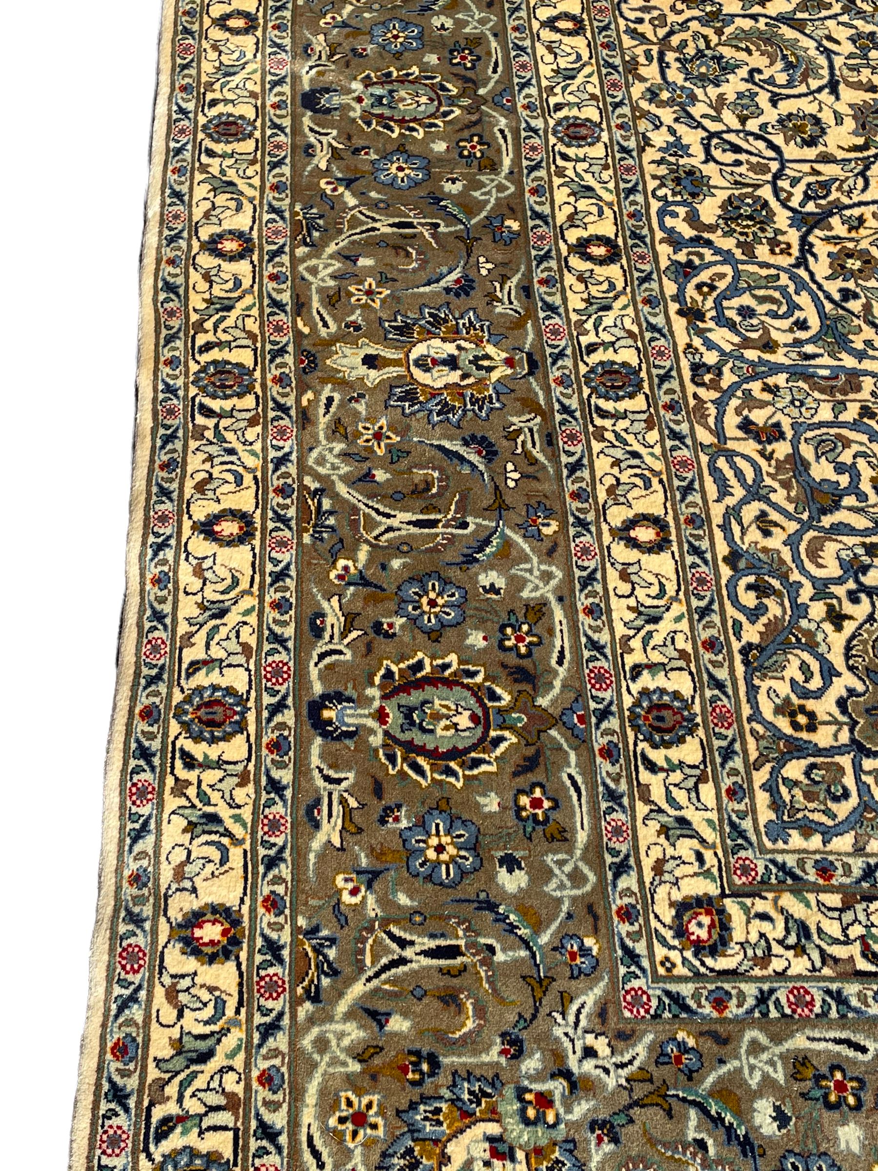 Persian Meshed carpet, ivory ground and decorated with intricate floral design with trailing scrolled branch, the central medallion decorated with stylised plant motifs, seven band border, the main band decorated with scrolls and flower head motifs