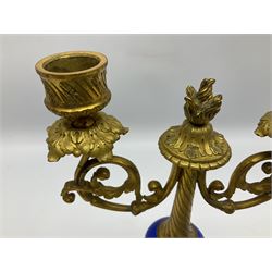 Pair of 19th century French ormolu and porcelain candlesticks, each with circular stepped foliate cast base with beaded rim and porcelain band, upon three knop feet, leading to a compressed spherical porcelain knop painted with a band of flowers between gros bleu type borders, and tapering stem with flambeau finial, supporting twin scrolling branches leading to sockets above foliate cast drips pans, H24.5cm