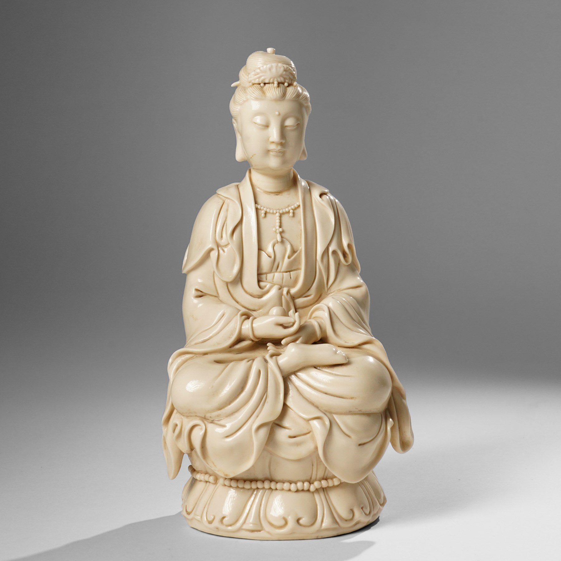 Three Chinese blanc de chine figures, each depicting Guanyin seated, Dehua province, two with double gourd and potters seal marks to the reverse 