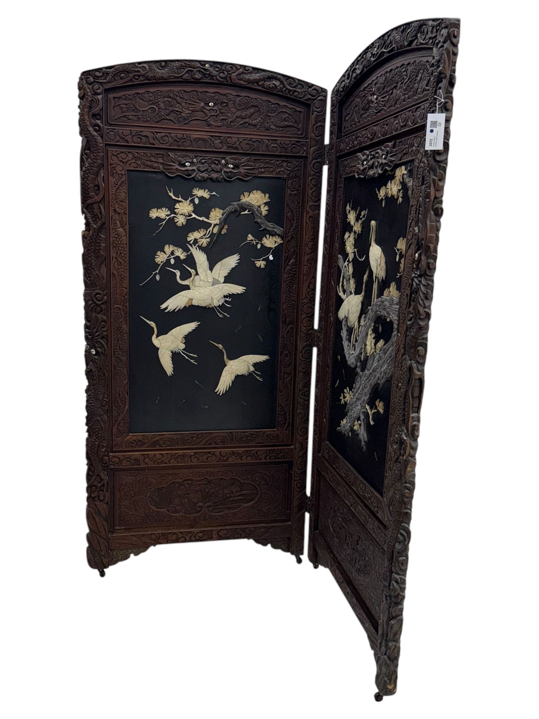 Meiji period (1868–1912), Shibayama lacquer carved hardwood two-fold screen inlaid with mother-of-pearl, bone, and ivory, decorated on one side in high relief and inlaid in a  Shibayama manner with oriental storks flying below flowering branches,  the reverse lacquer panels depicting flowering cherry trees. This item has been registered for sale under section 10 of the APHA Ivory Act.