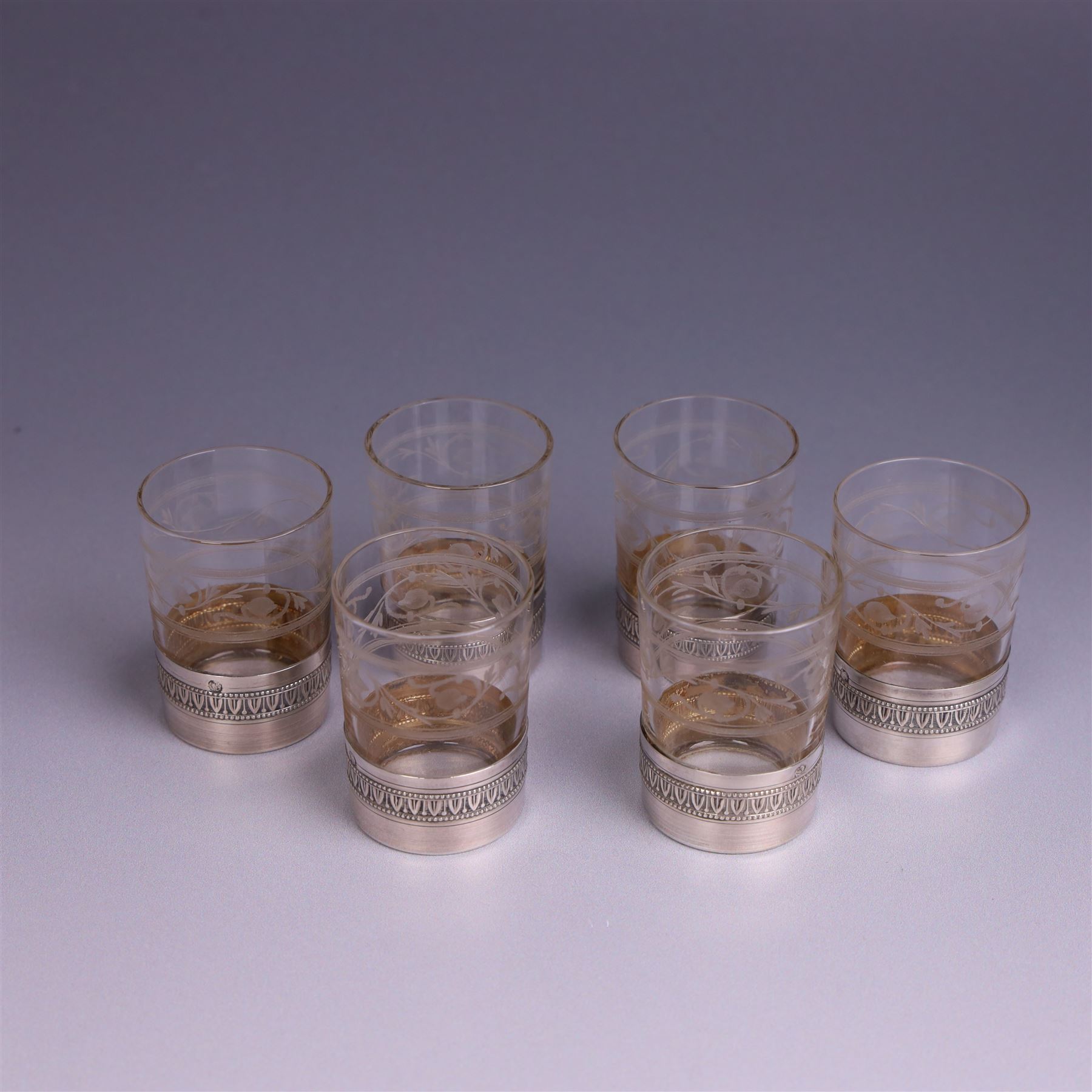 French silver mounted glass decanter and shot glass set, the decanter with silver covered stopper, removable silver collar, and etched decoration to glass body, the six silver mounted glasses each with etched decoration, silver stamped with Minerva's head, decanter H 21cm