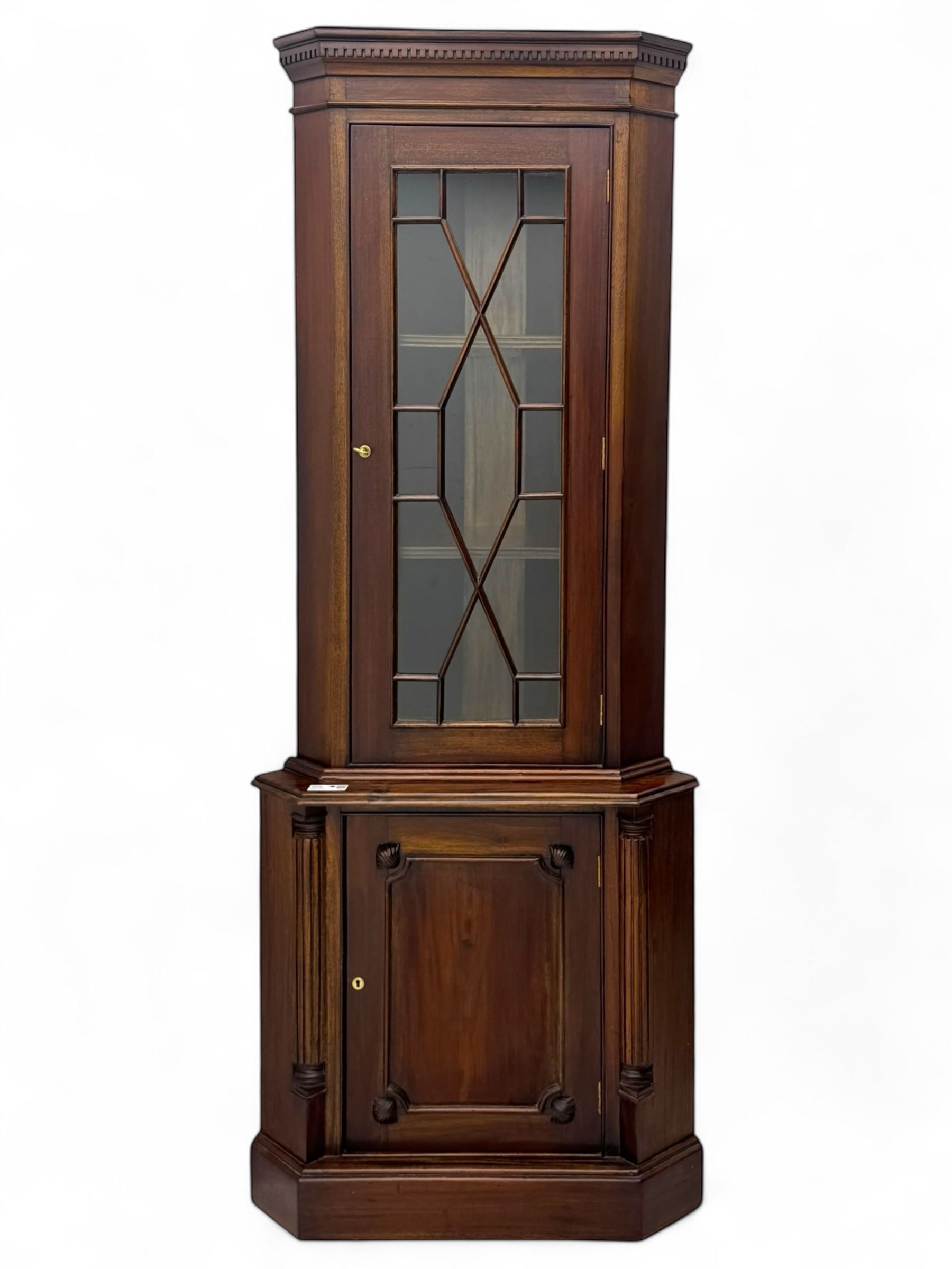 Late 20th century mahogany corner cabinet, dentil moulded cornice above a glazed door with astragal glazing enclosing two shelves, lower cupboard with fielded panel door and turned shell motif, on plinth base
