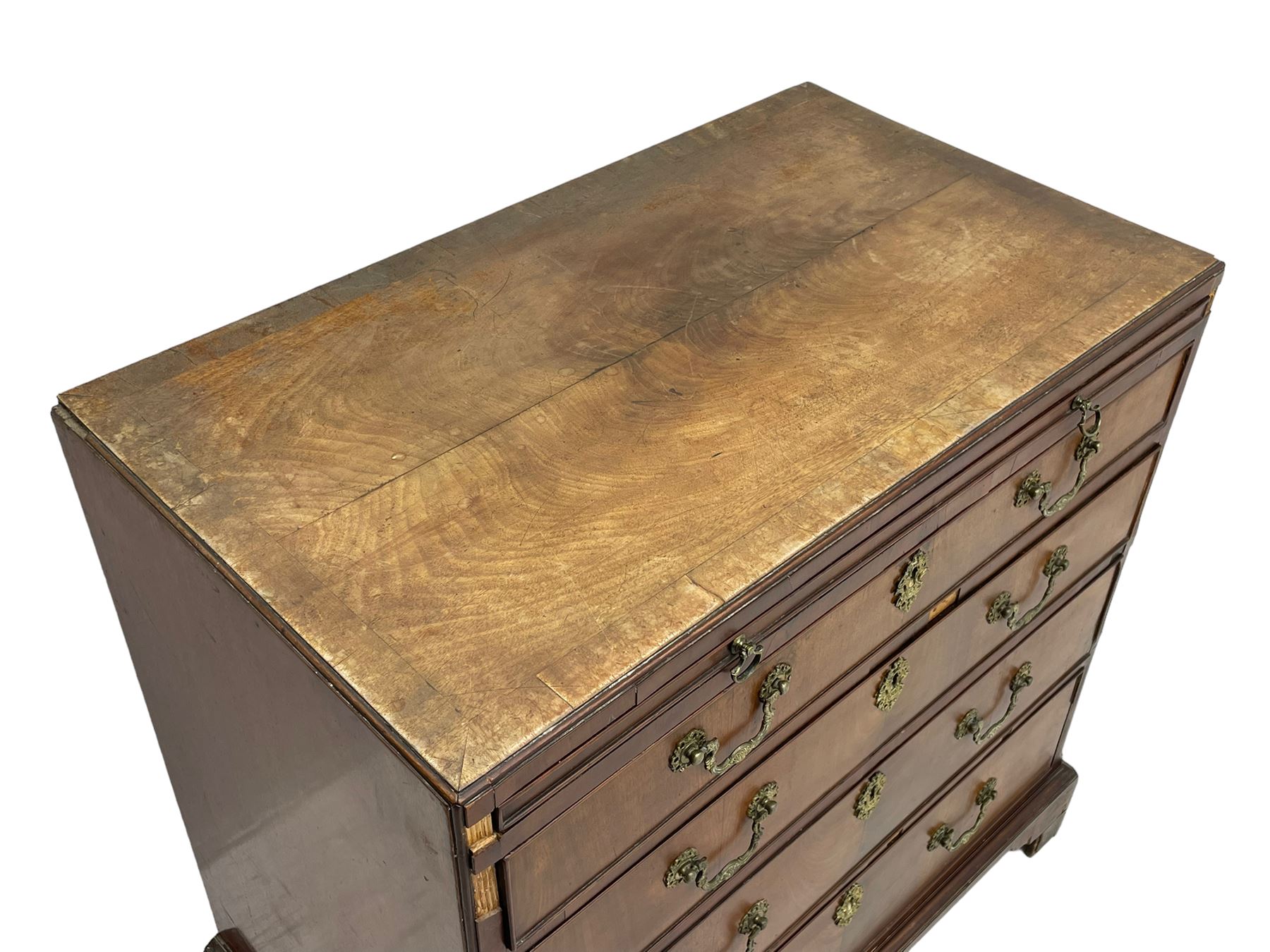 George III mahogany chest, banded caddy top with moulded edge, brushing slide over four graduating cock-beaded drawers, ornate cast gilt metal handle plates and escutcheons, swan neck handles cast with dolphins, shells and C-scrolls, lower moulding over bracket feet