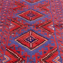 Afghan Meshwani runner, hand-knotted wool pile, indigo ground decorated with a vertical series of angular diamond medallions in tones of madder red, dark blue, framed by geometric borders with flatwoven kilim ends with fringe 
