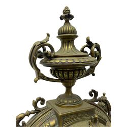 French - Late 19th century brass cased 8-day mantle clock, with a break arch top surmounted by a reeded urn with handles, brake front case with finials and recessed reeded columns on a stepped plinth raised on scroll feet,  brass dial with cartouche roman numerals and brass hands within a glazed dial bezel, twin train rack striking movement, striking the hours and half-hours on a bell. With pendulum. 