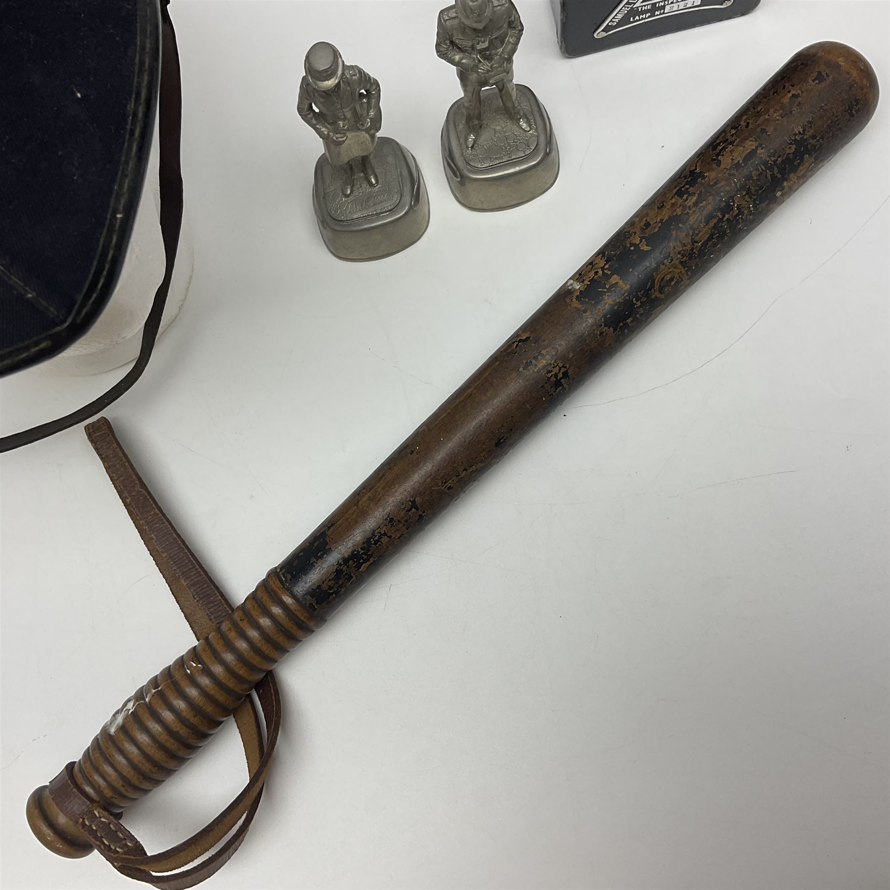 Police - Victorian turned hardwood truncheon with traces of decoration and VR cypher L42cm; Humberside Police helmet with Queens Crown helmet plate; hand lamp inscribed 'The Inspector'; and small pair of pewter figures of police officers (5)