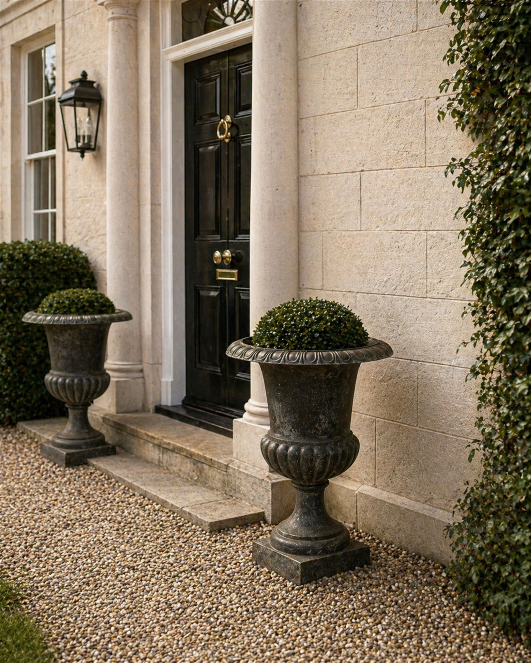 Pair of Victorian design heavy cast iron garden urns, black painted, egg and dart rim on waisted column