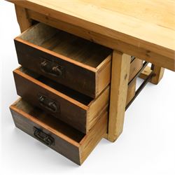 Mid-20th century pitch pine and beech bakers table, three quarter galleried rectangular plank top, three drawer pedestal with iron handles and runners, square supports with iron spandrel, raised on castors 