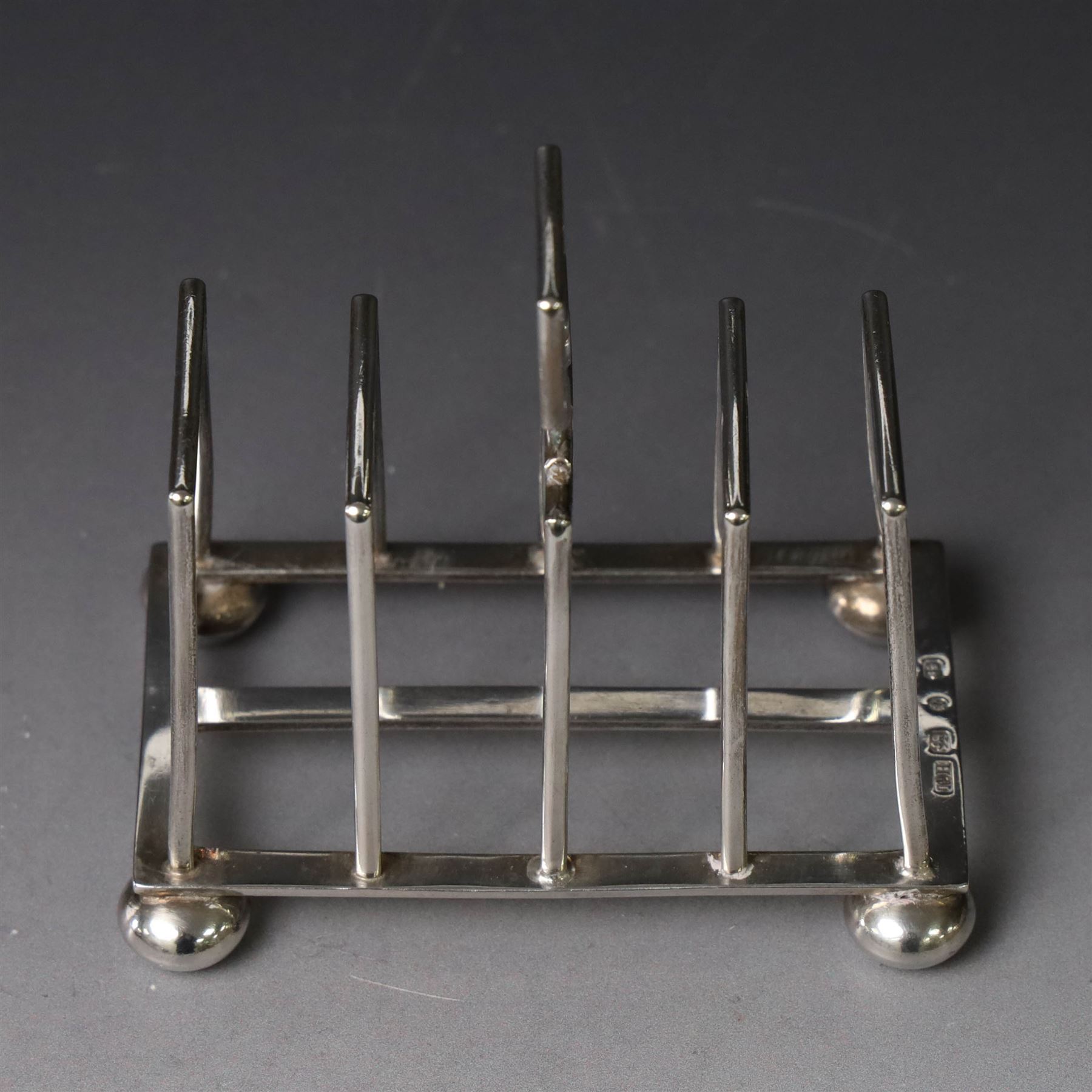 Victorian silver toast rack, with five angular bars and loop handle, upon four squat bun feet, hallmarked Thomas Hayes, Birmingham 1893, height including handle H10cm
